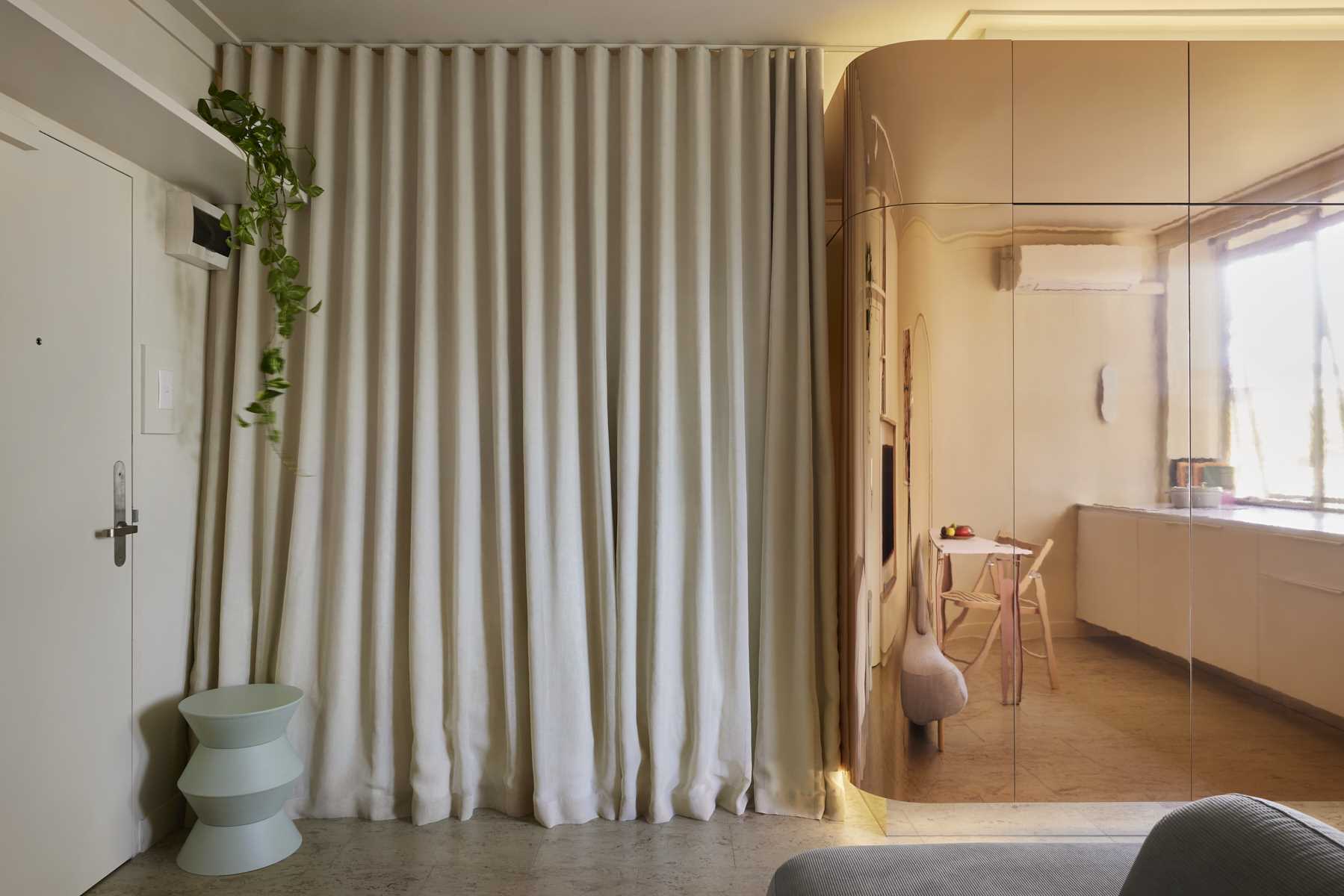 In this micro apartment, a floor-to-ceiling curtain can be pulled closed for privacy and to block the light.