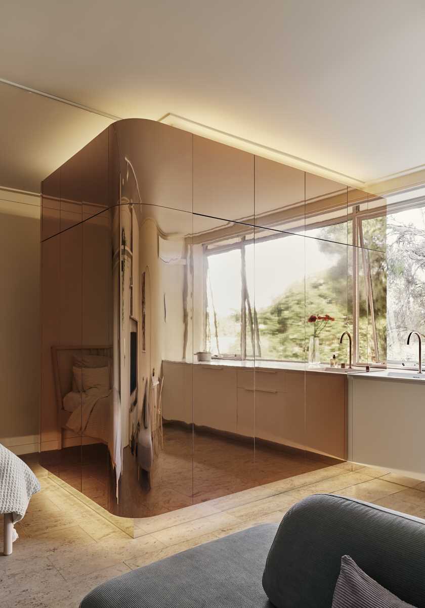 A multi-functional brass clad pod in a micro apartment houses the bathroom, wardrobe, and kitchen cabinets.