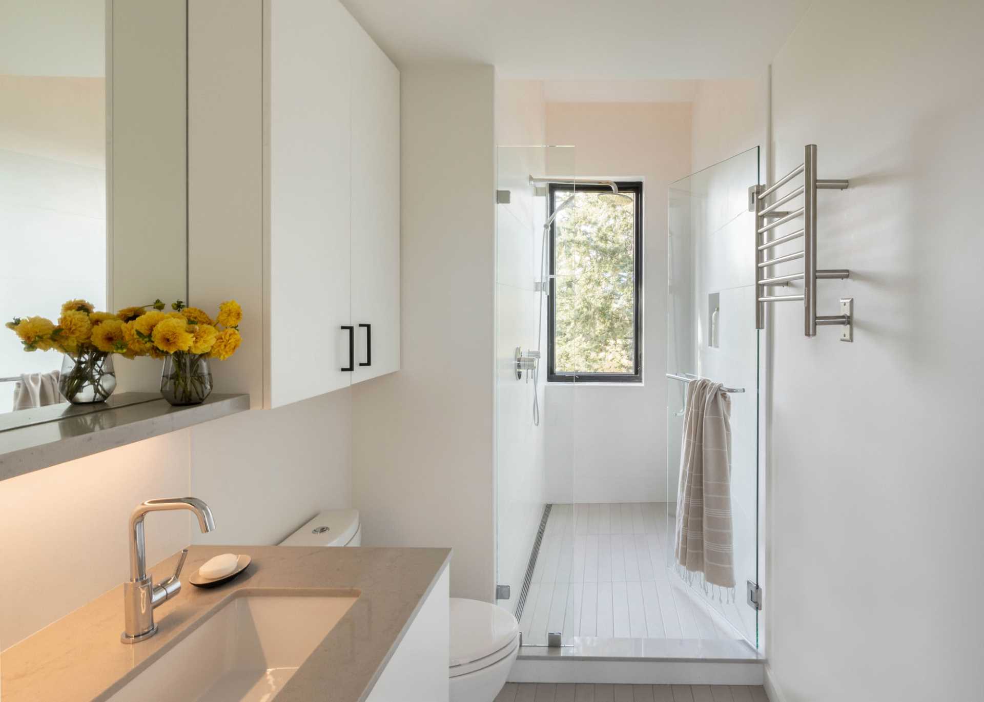 A modern bathroom with a vertical window in the shower.