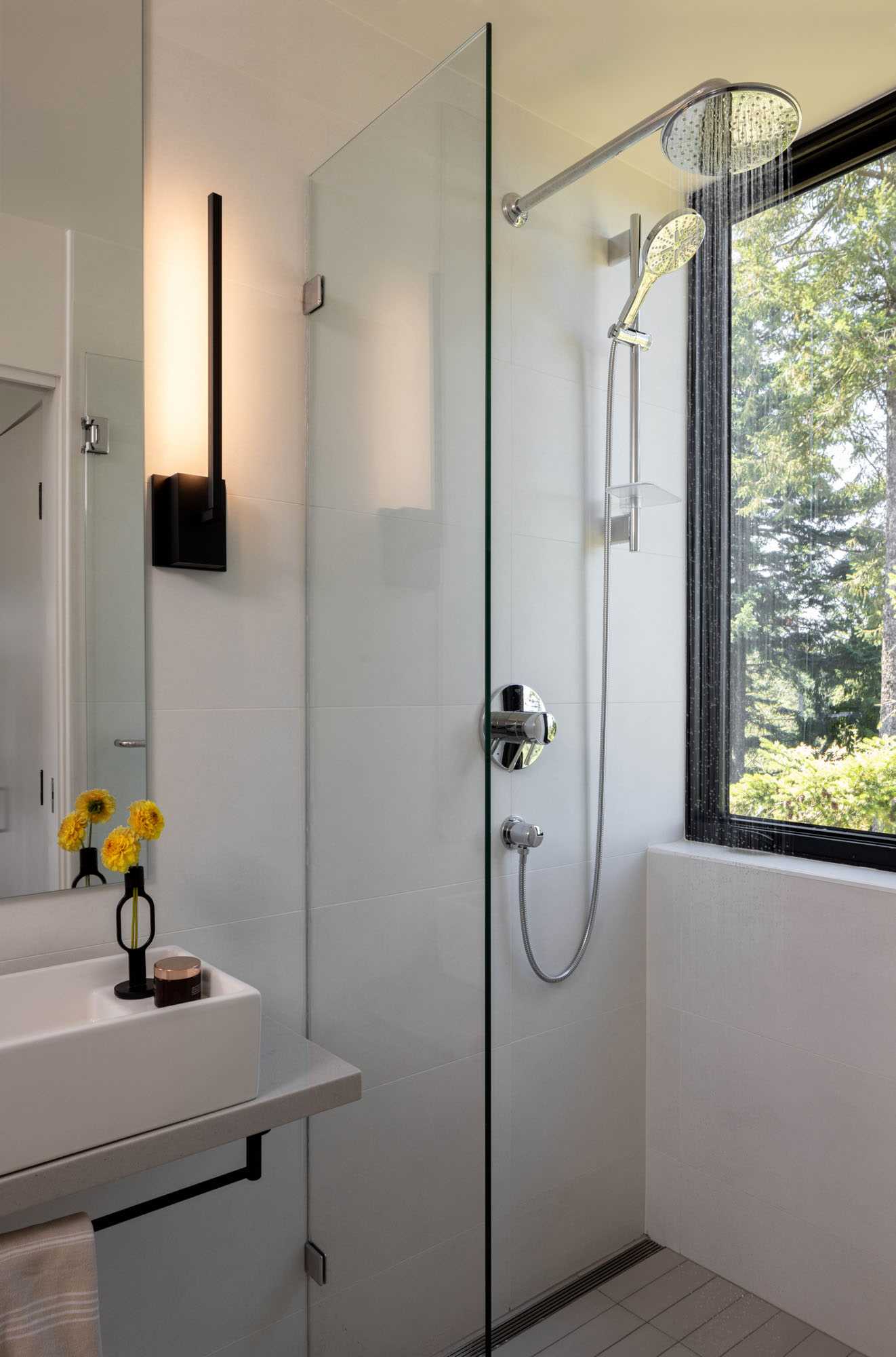 A modern bathroom with a vertical window in the shower.