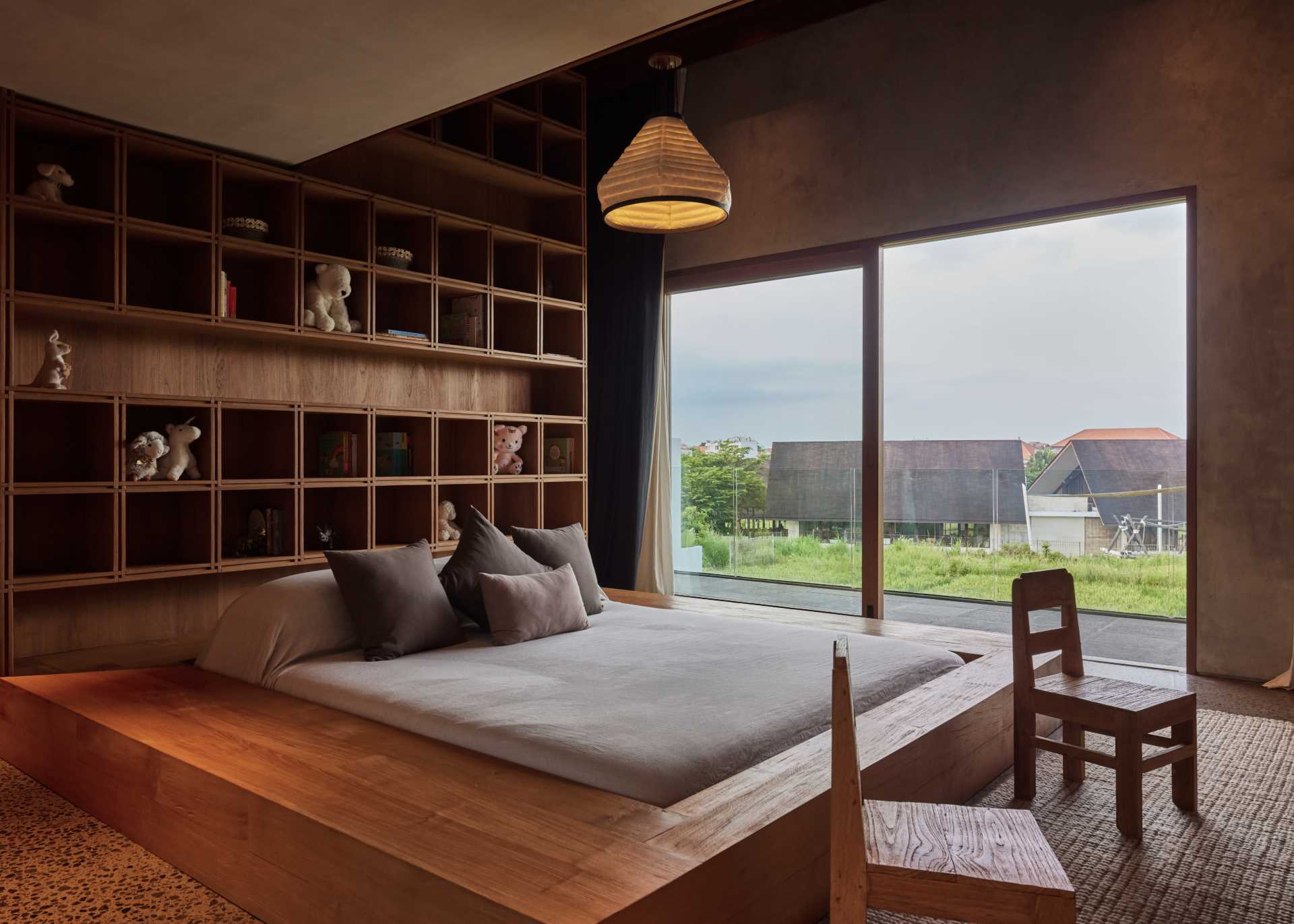 In this bedroom, a wood frame surrounds the bed, while a custom shelving unit lines the wall.