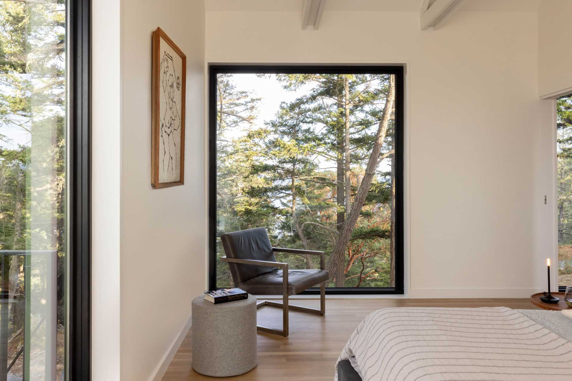 A modern bedroom with a large picture window to frame the free views.