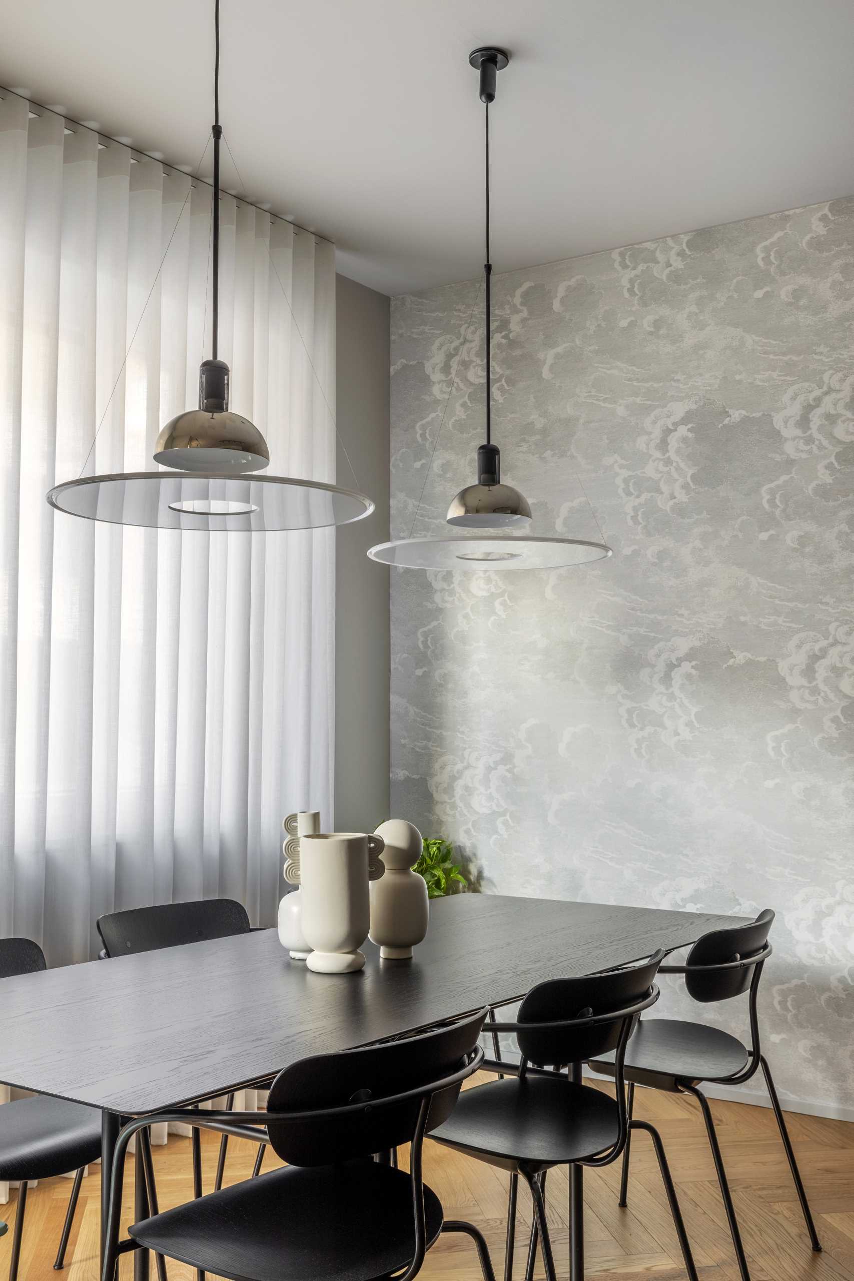 Wallpaper lines the wall that spans the kitchen and the dining area, adding a subtle elegant touch to the interior.