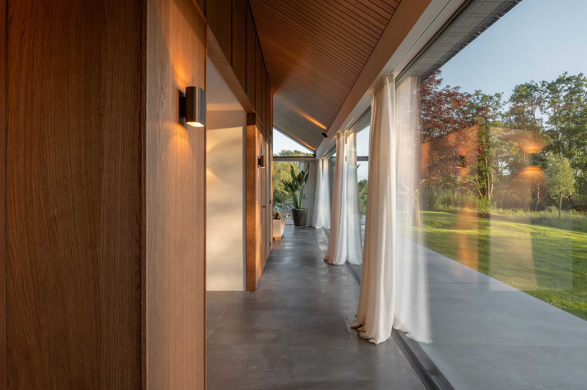 In the hallway of this modern home, you can see how the concrete floor extends from inside the house to the exterior.