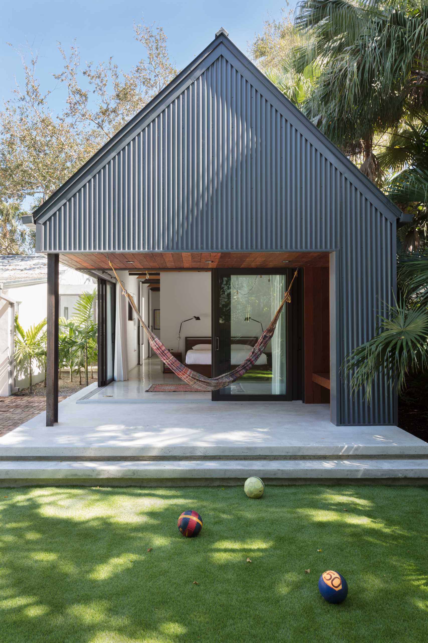 The patio off this primary bedroom is home to a hammock and a built-in wood bench.