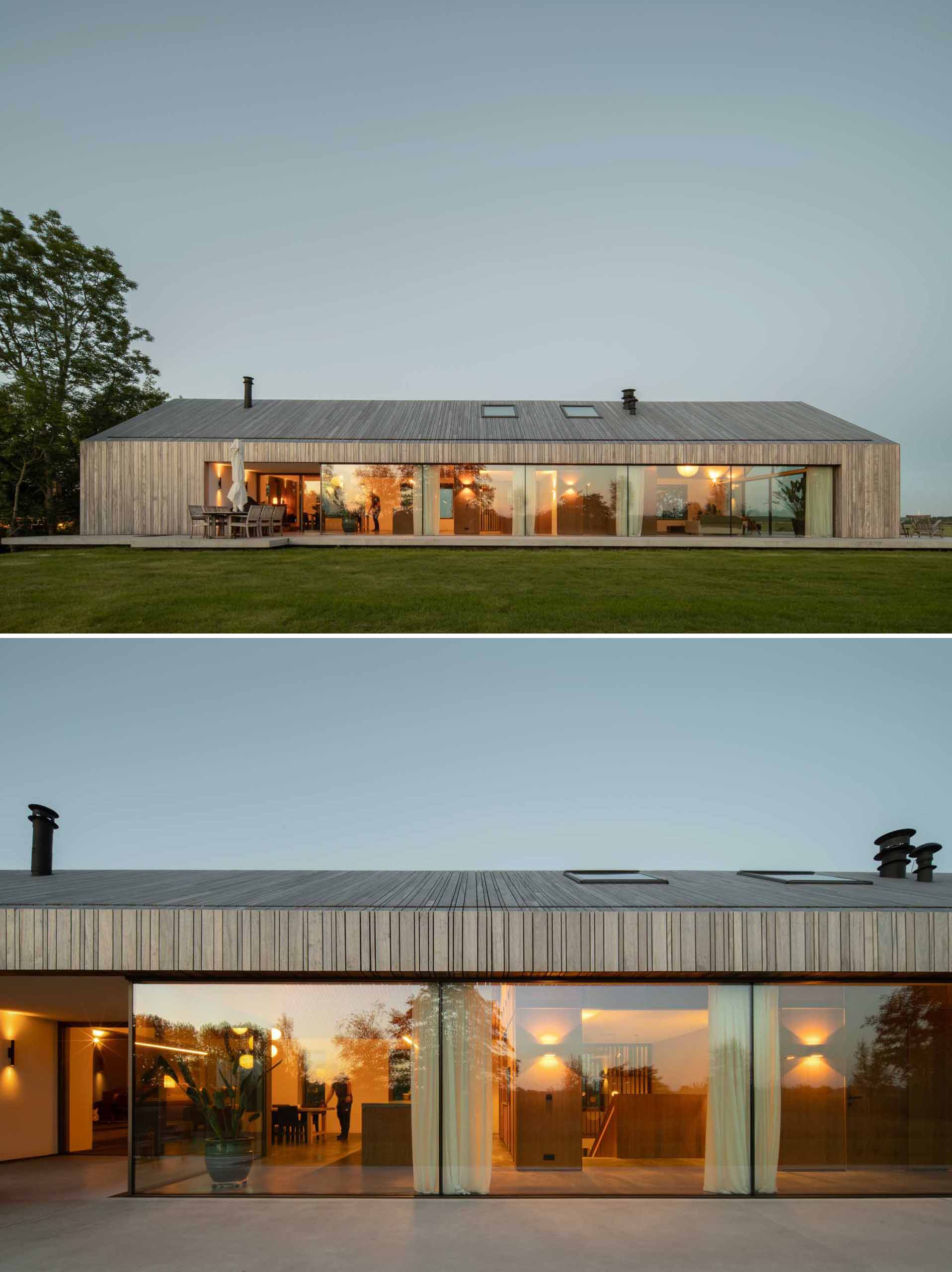 The roof material of this modern home extends down the facade, while glass walls flood the interior with natural light.