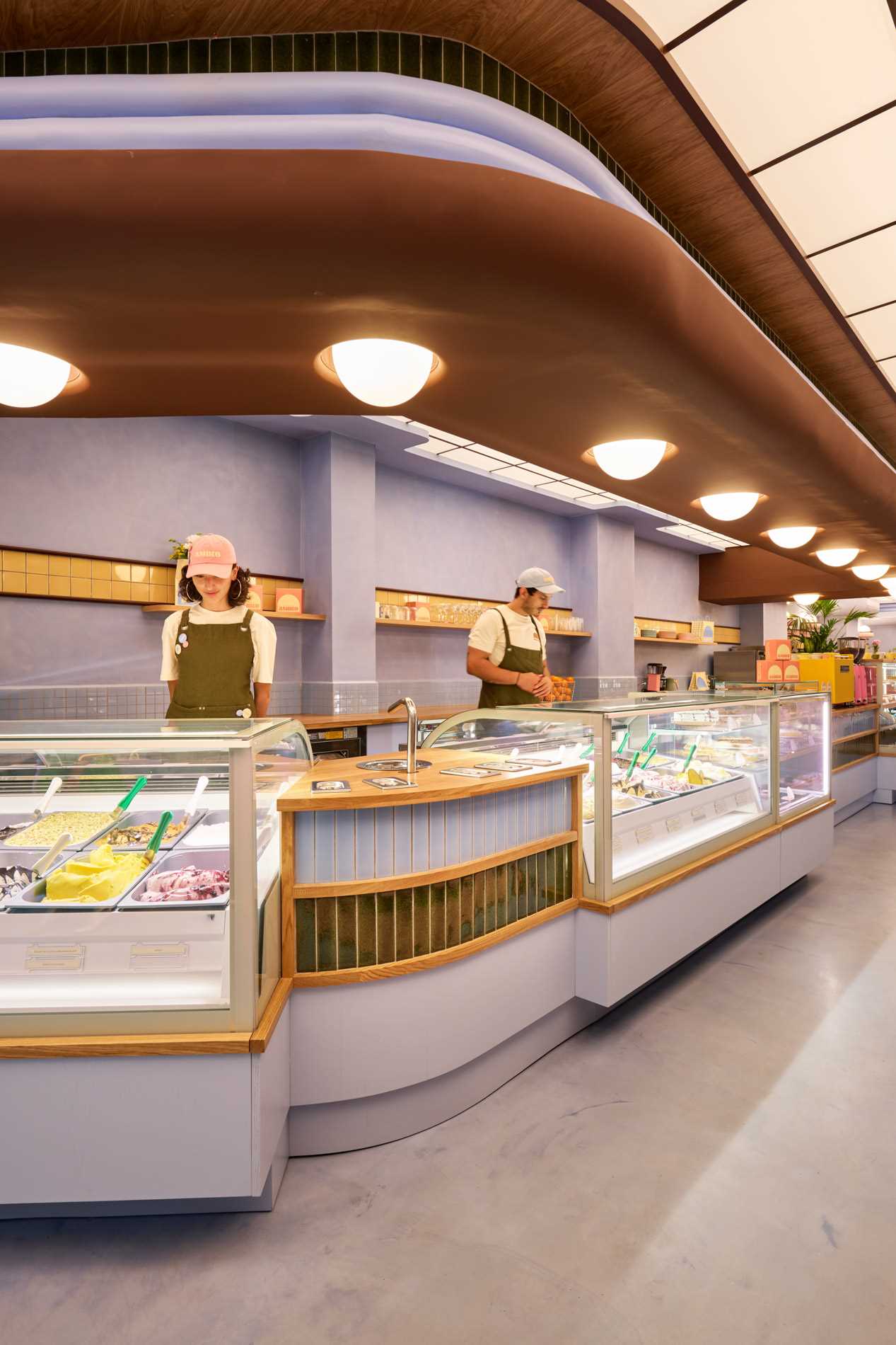 The interior design of Amiko Gelato blends futuristic design with art deco elements, like curves, glazed tiles, and pastel colors.