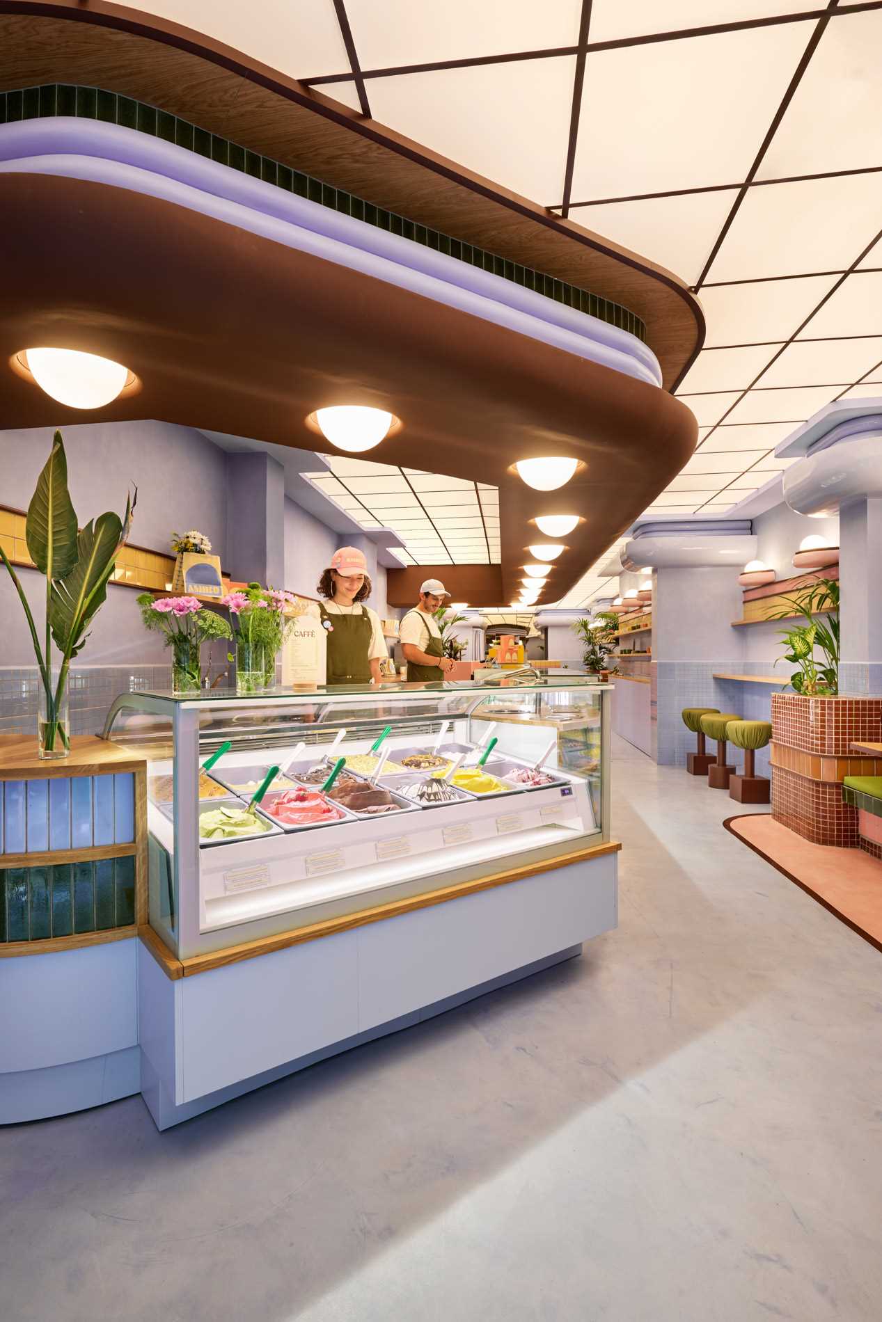 The interior design of Amiko Gelato blends futuristic design with art deco elements, like curves, glazed tiles, and pastel colors.