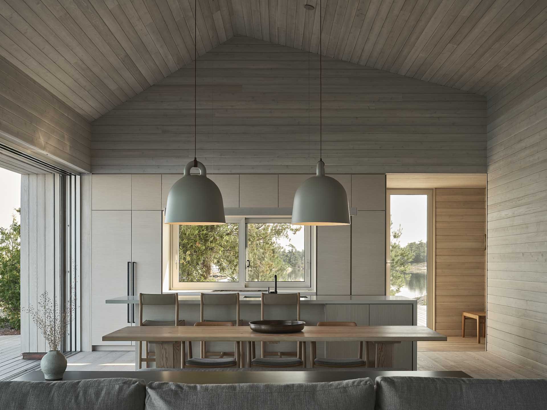 An open-plan dining room separates the living room and the kitchen, while two large pendant lights add visual interest.