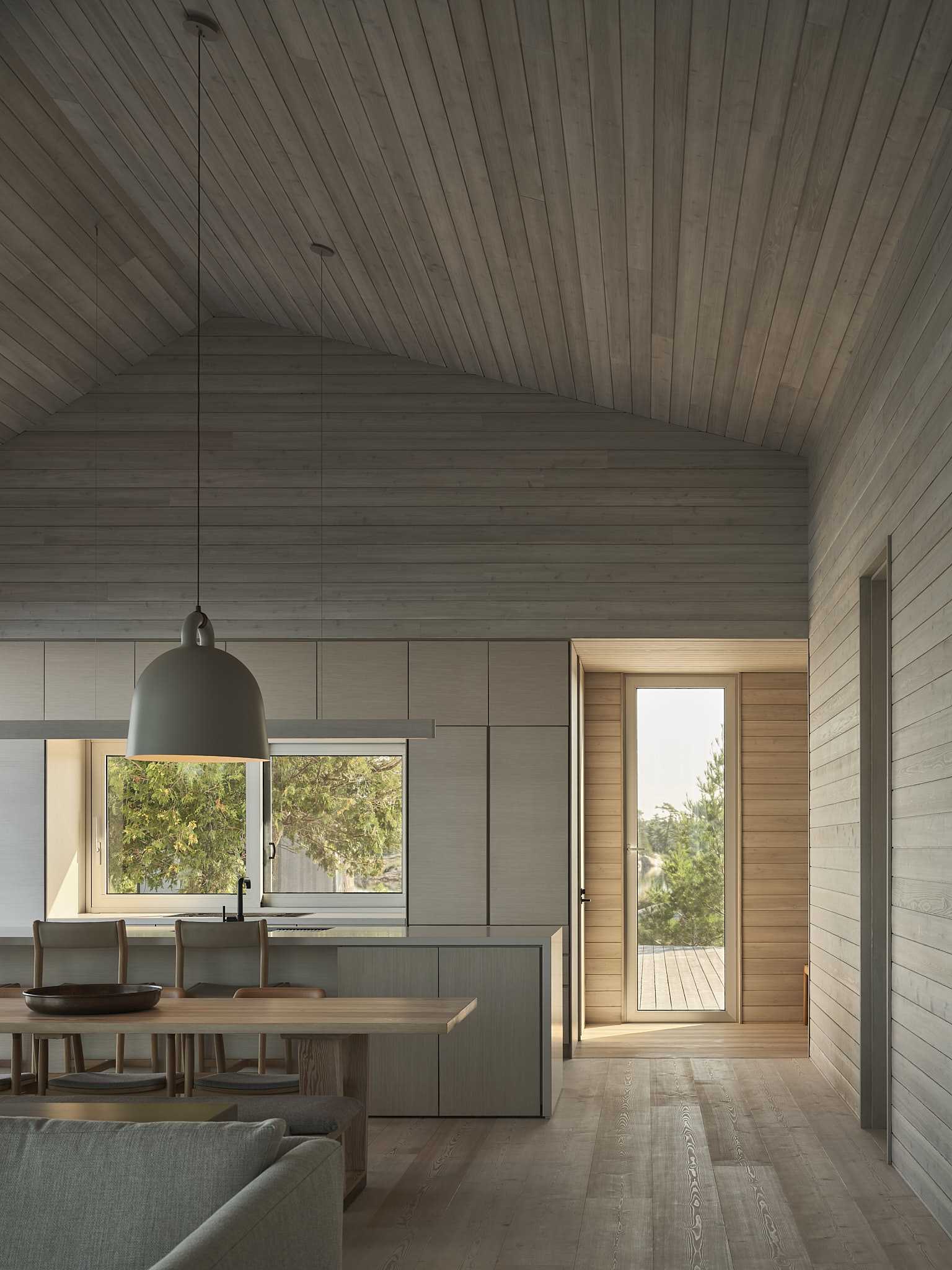 An open-plan dining room separates the living room and the kitchen, while two large pendant lights add visual interest.