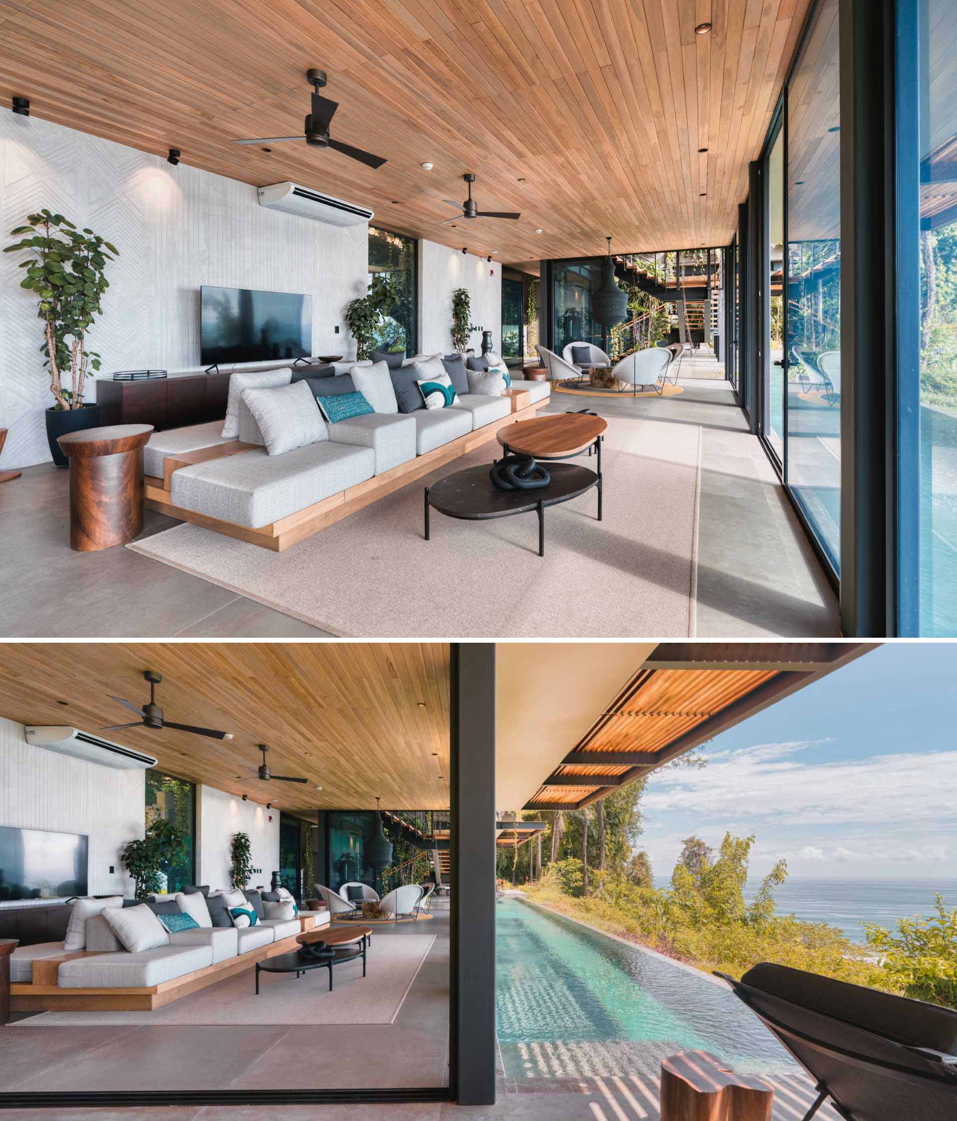 This modern living room has a double-sided couch for watching TV or watching the views, as well as a smaller sitting area with four chairs centered around a wood table and a sculptural pendant light.