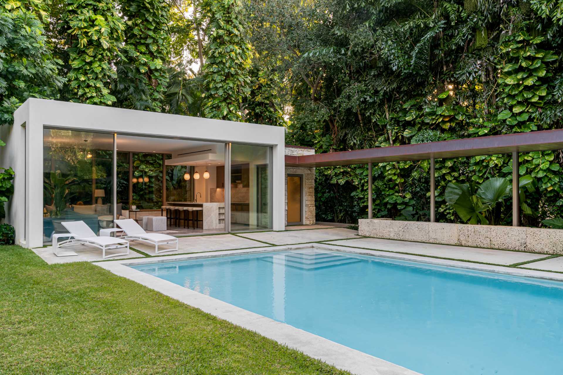 A modern backyard pavilion houses a living room, kitchen, and bathroom, and is connected to the home by a loggia (outdoor corridor).