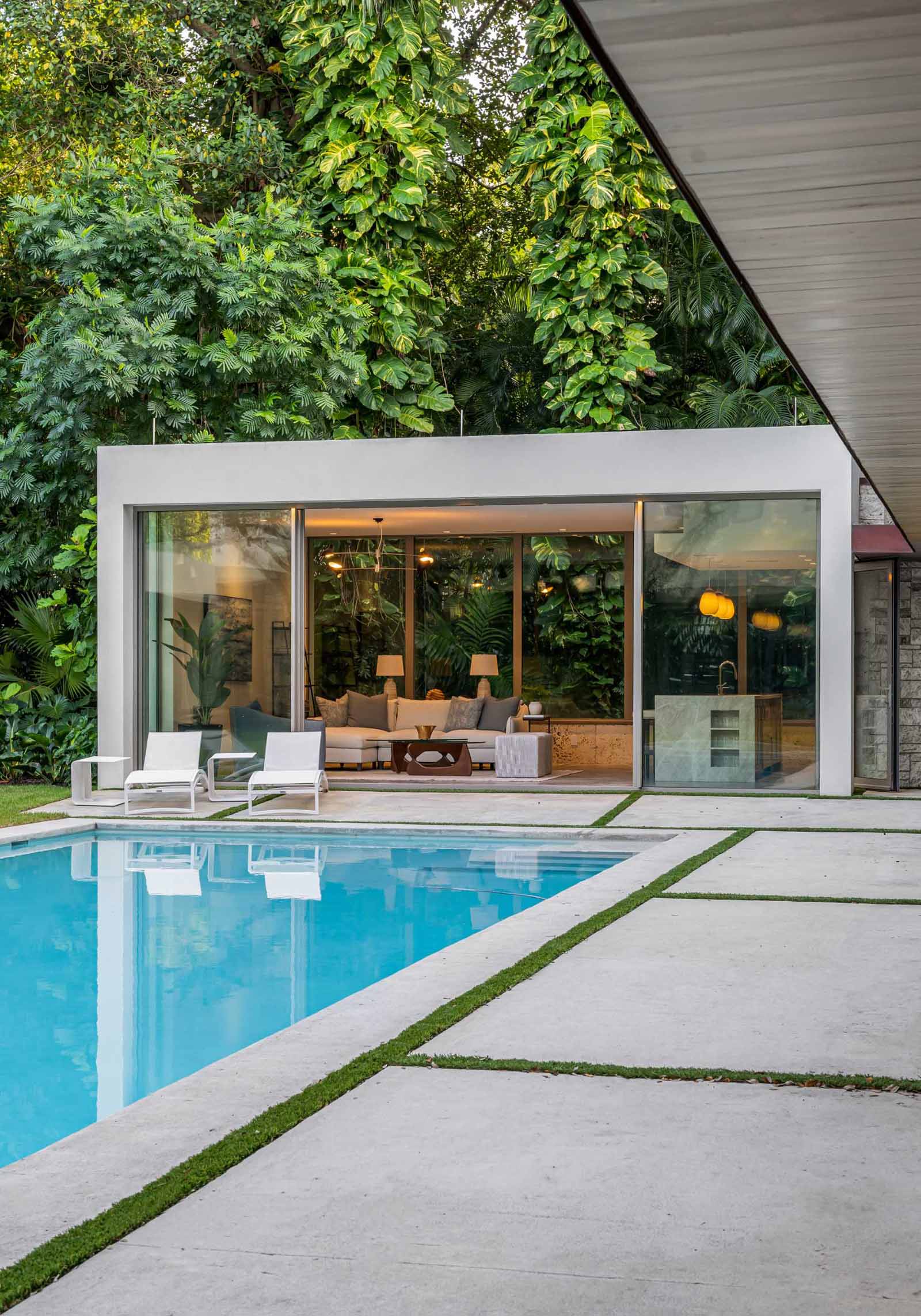 A modern backyard pavilion houses a living room, kitchen, and bathroom, and is connected to the home by a loggia (outdoor corridor).