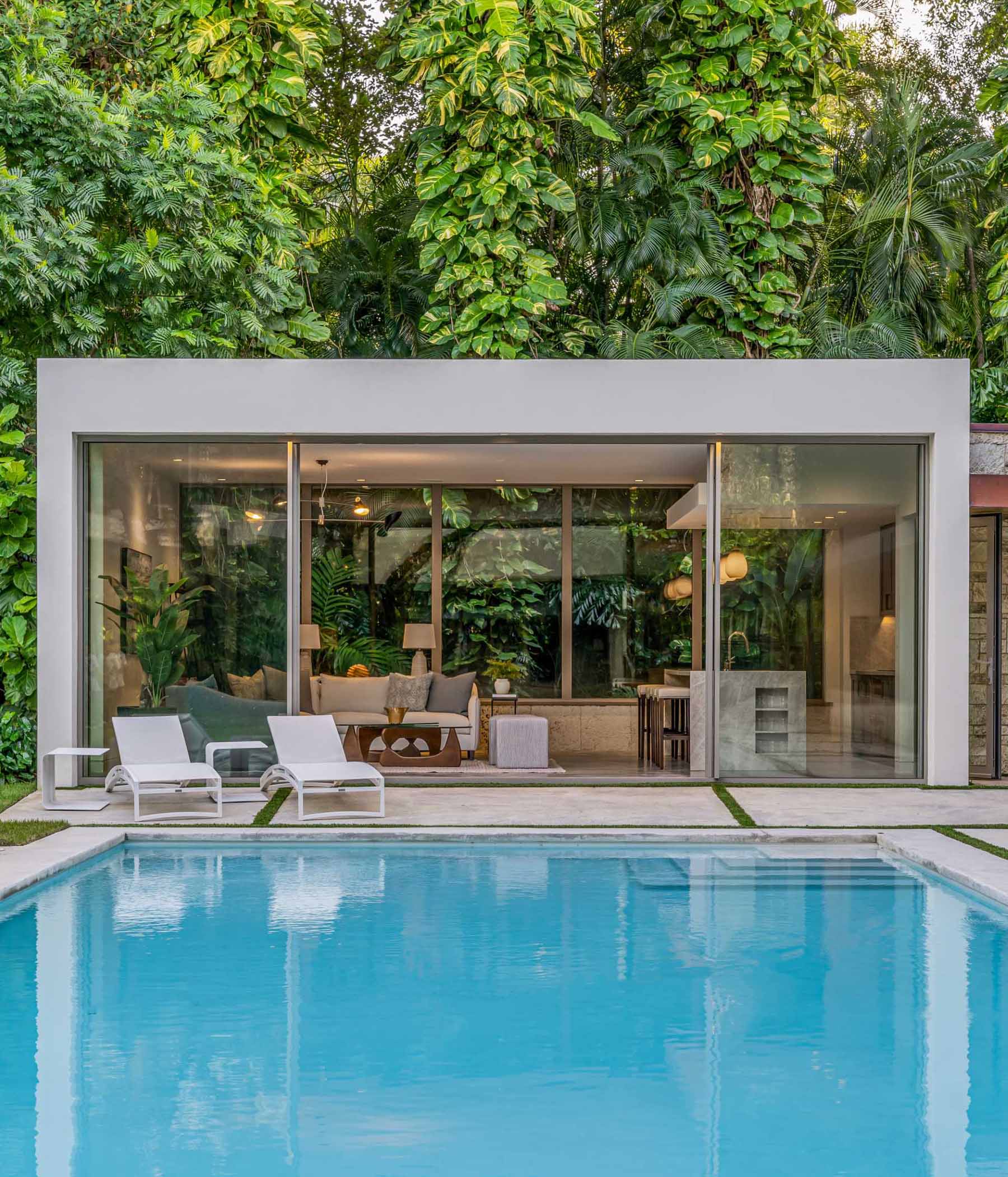 A modern backyard pavilion houses a living room, kitchen, and bathroom, and is connected to the home by a loggia (outdoor corridor).