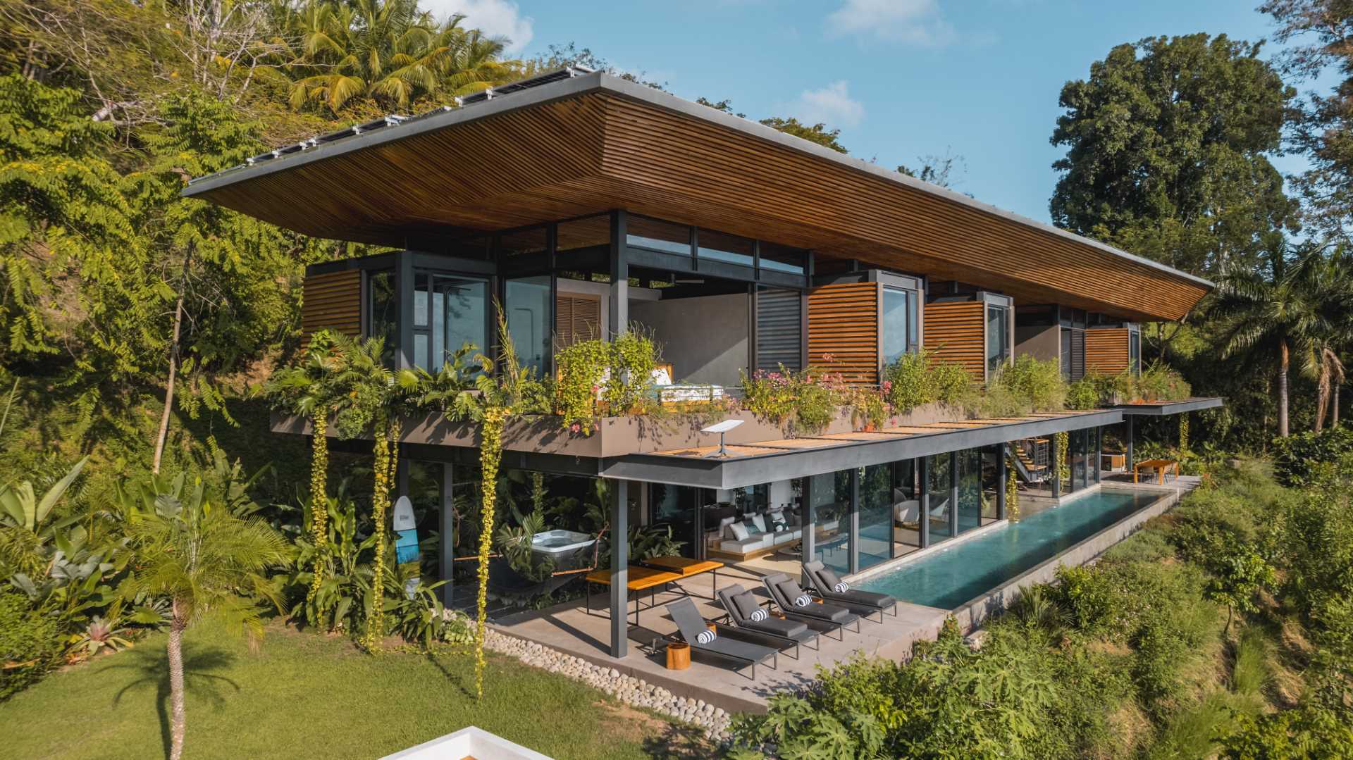 A modern tropical home with water views is designed to highlight its surroundings.