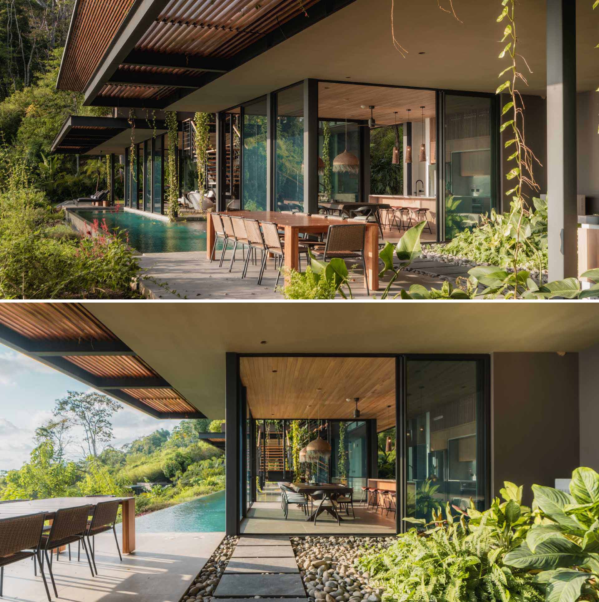 A modern home with outdoor spaces that include a series of sun lounges at one end of the pool and a dining area at the other.