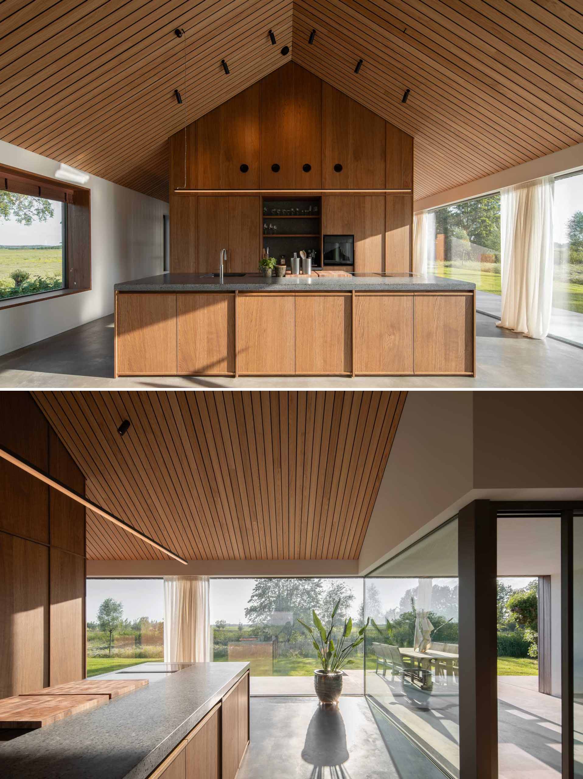 In the kitchen, wood cabinets are paired with a dark grey countertop, while the picture windows frame the view.