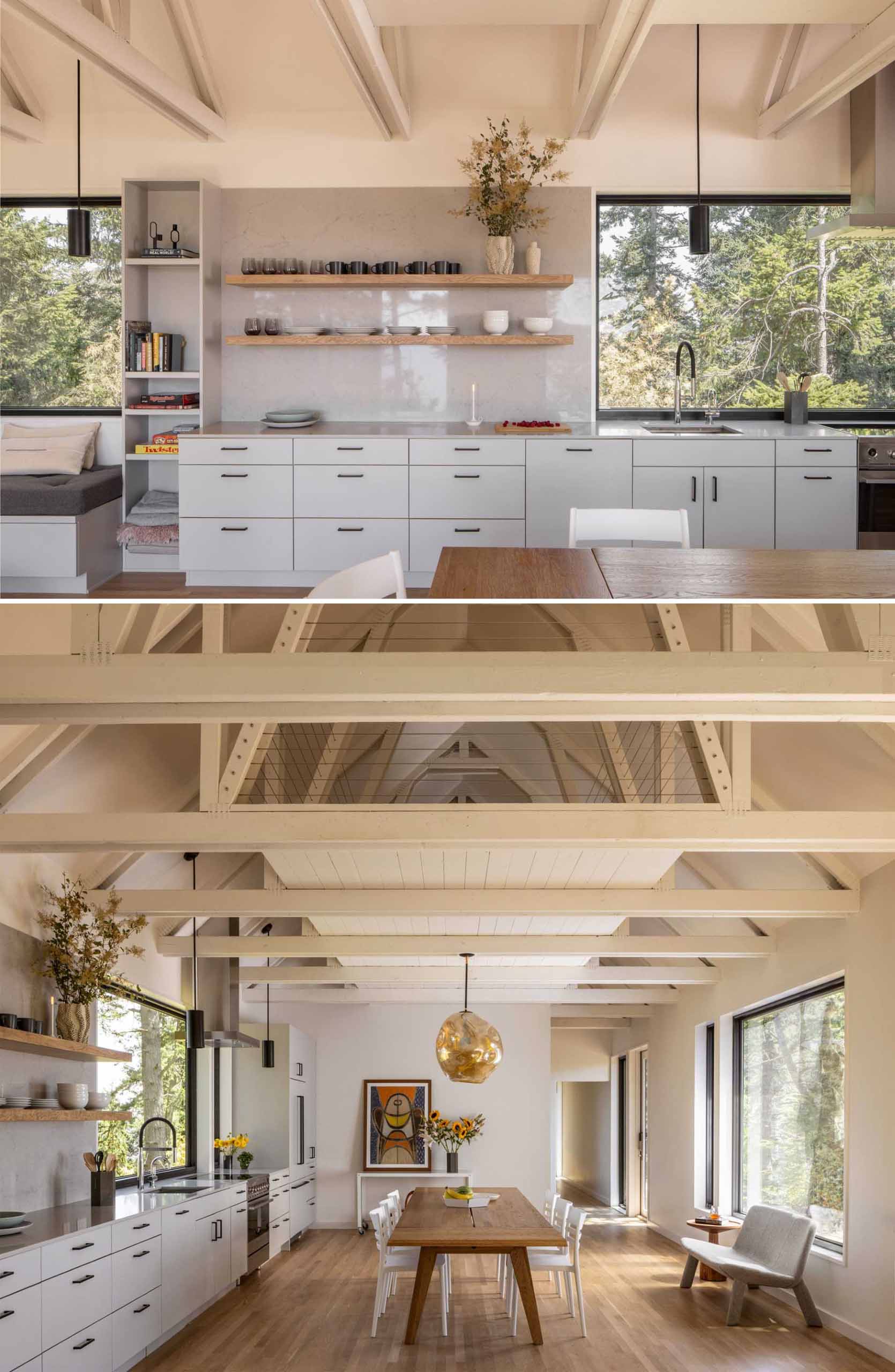 An open-plan dining area and kitchen includes a wood dining table, while the kitchen includes grey cabinets and floating wood shelving that lines the wall.