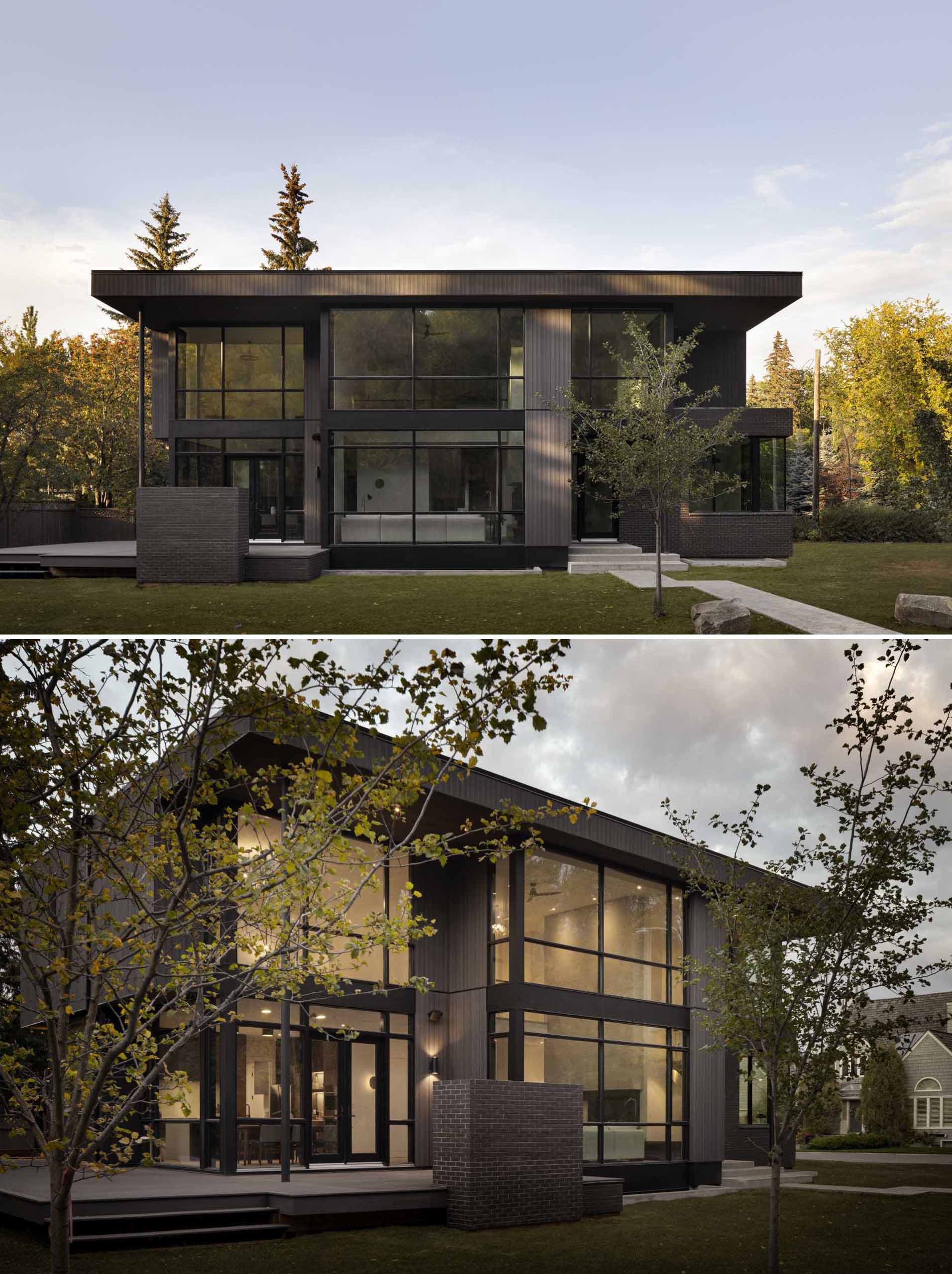 A modern home with a dark wood exterior complements the surrounding forest.