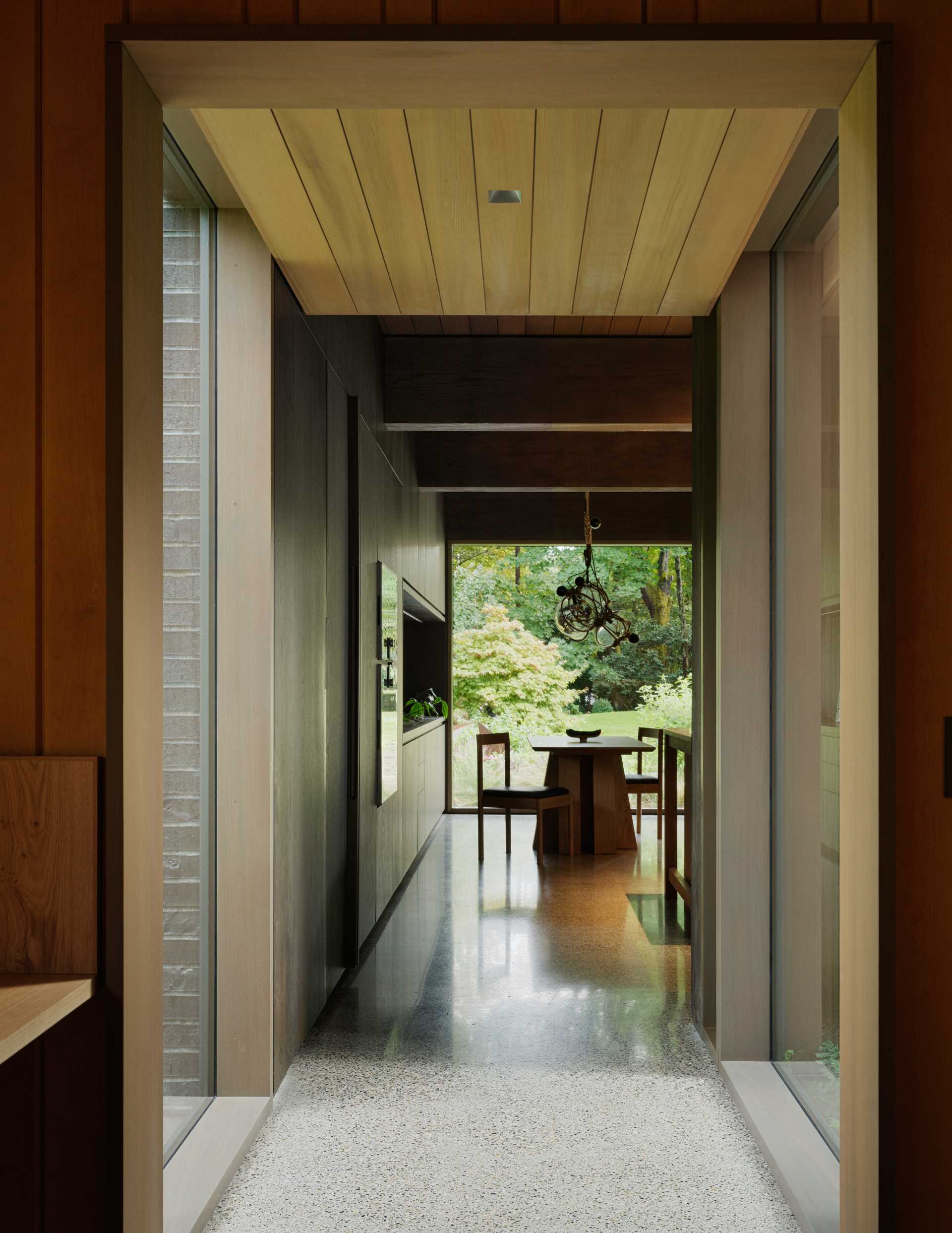 The hallway connecting the old with the new in this home includes floor-to-ceiling windows that provide a glimpse of the outdoors.