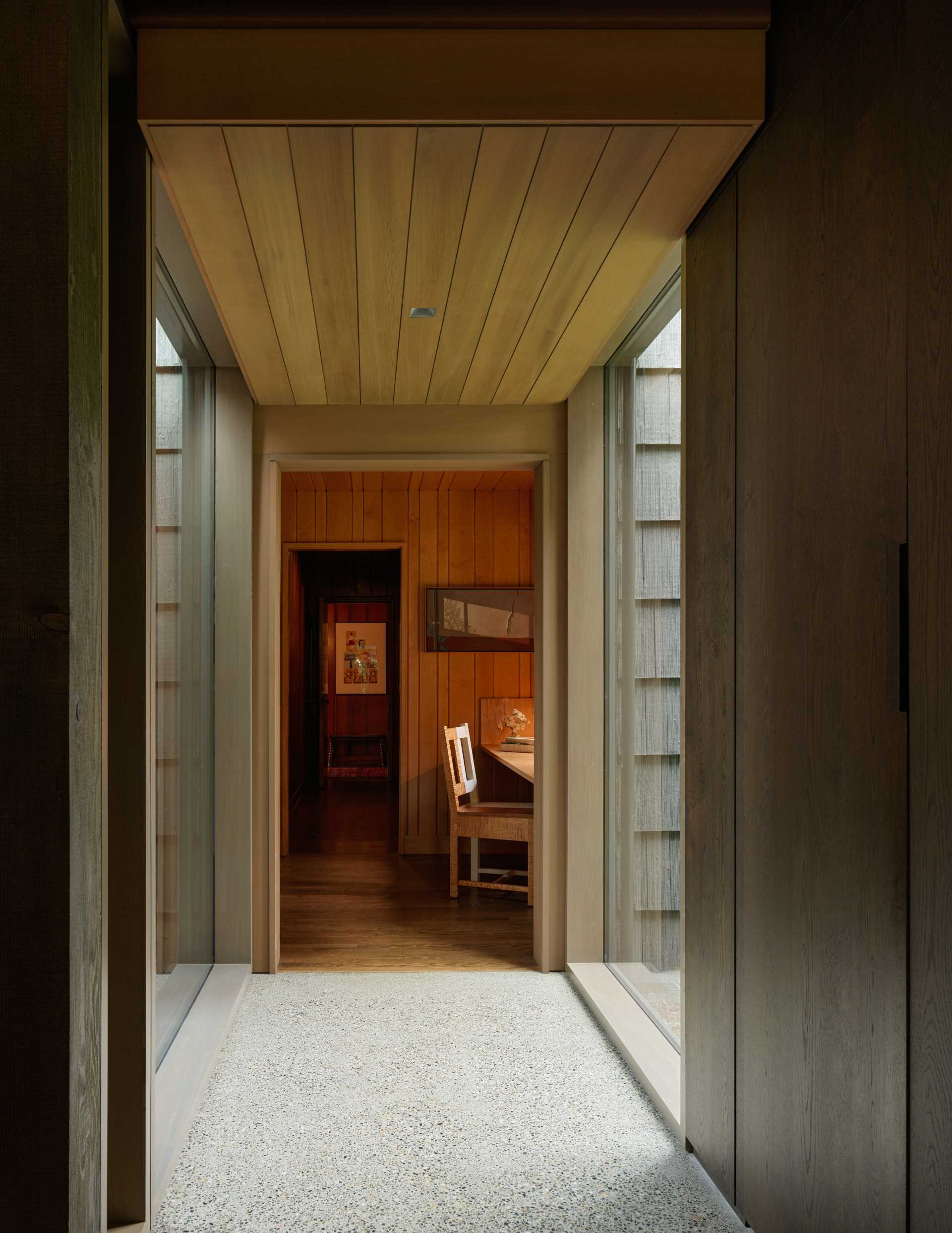 The hallway connecting the old with the new in this home includes floor-to-ceiling windows that provide a glimpse of the outdoors.