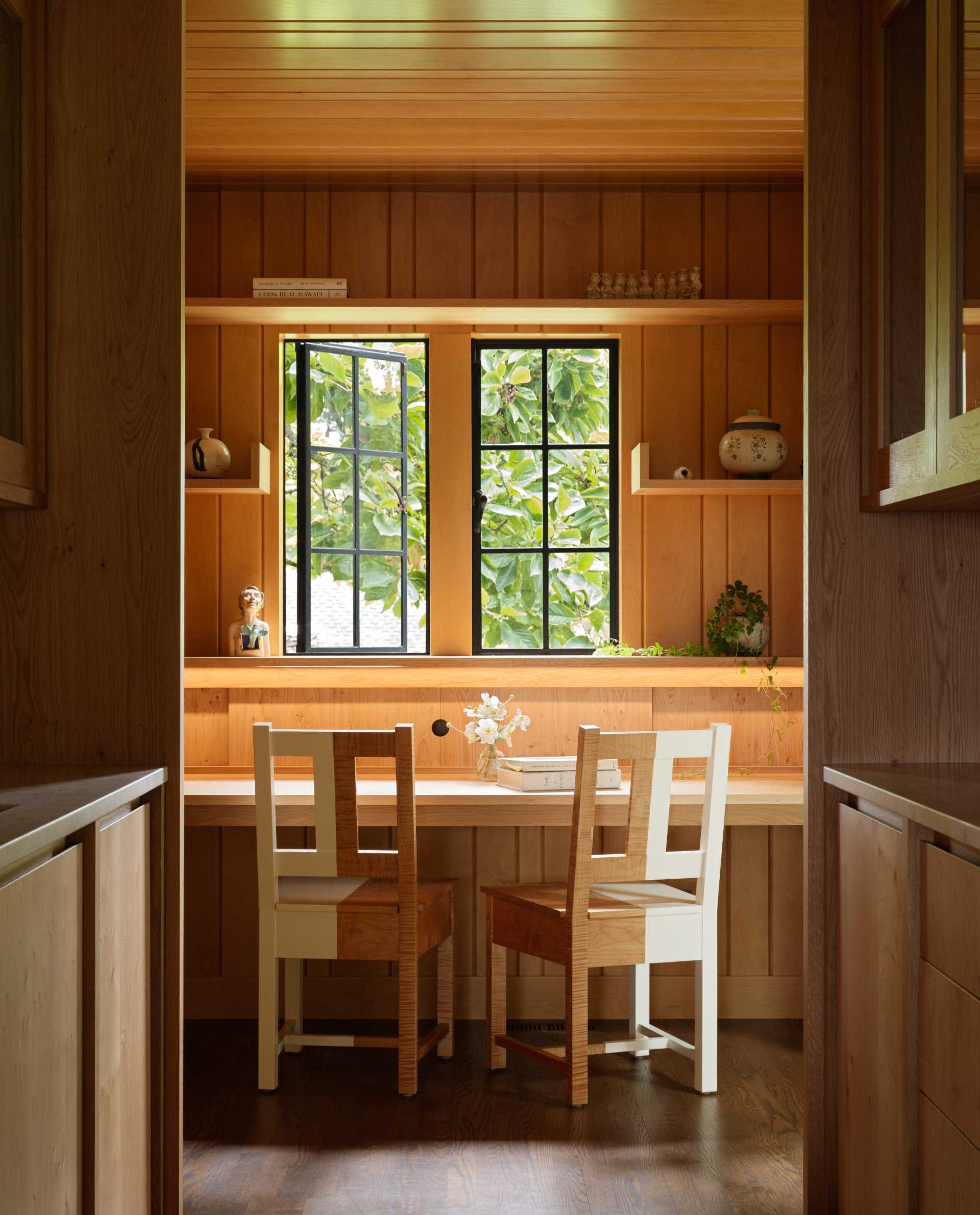 A contemporary home office with built-in desk and shelving.