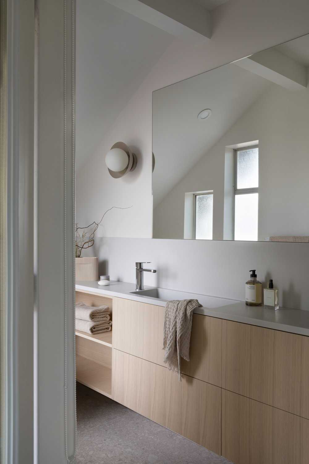 A modern coastal-inspired bathroom with a neutral and contemporary color palette.