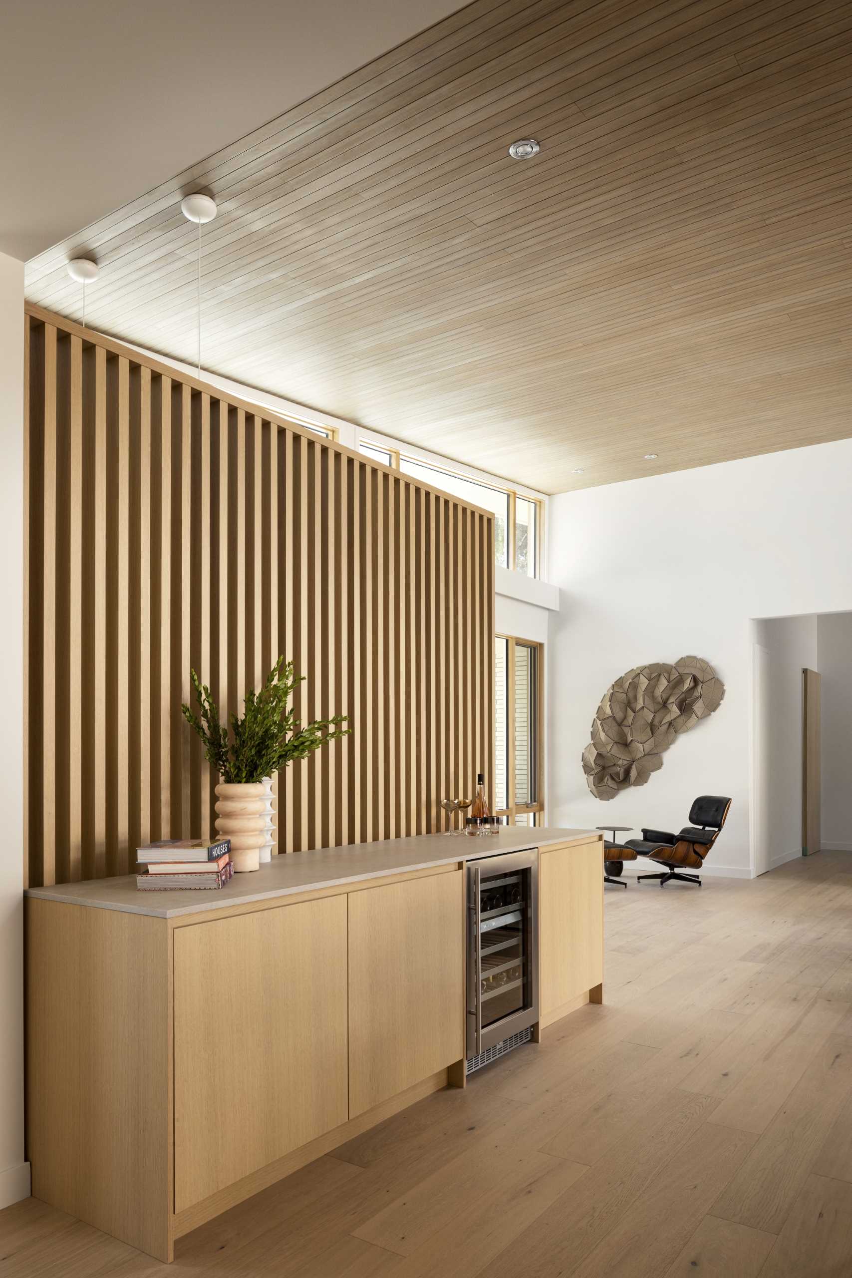 Oak slat partitions, like this one behind the credenza, carry the mid-century aesthetic throughout the home, dividing spaces while allowing light to flow between.