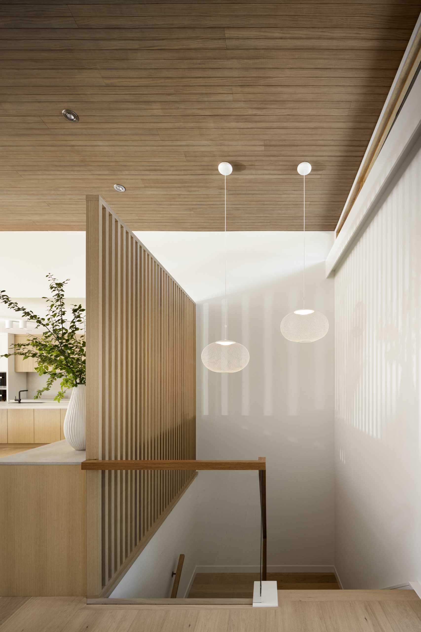 Oak slat partitions, like this one behind the credenza, carry the mid-century aesthetic throughout the home, dividing spaces while allowing light to flow between.