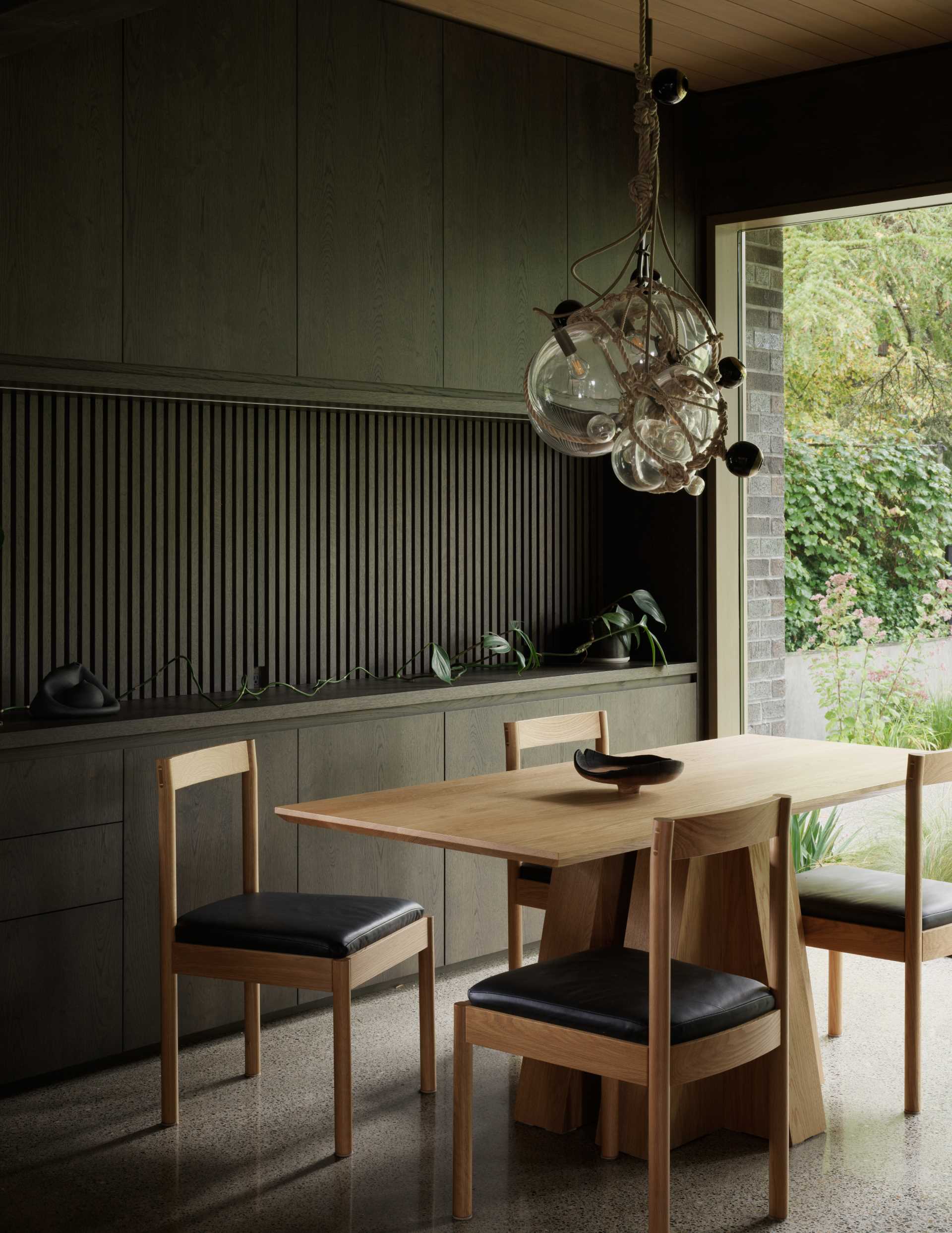 A contemporary breakfast nook with a large picture window and built-in storage.