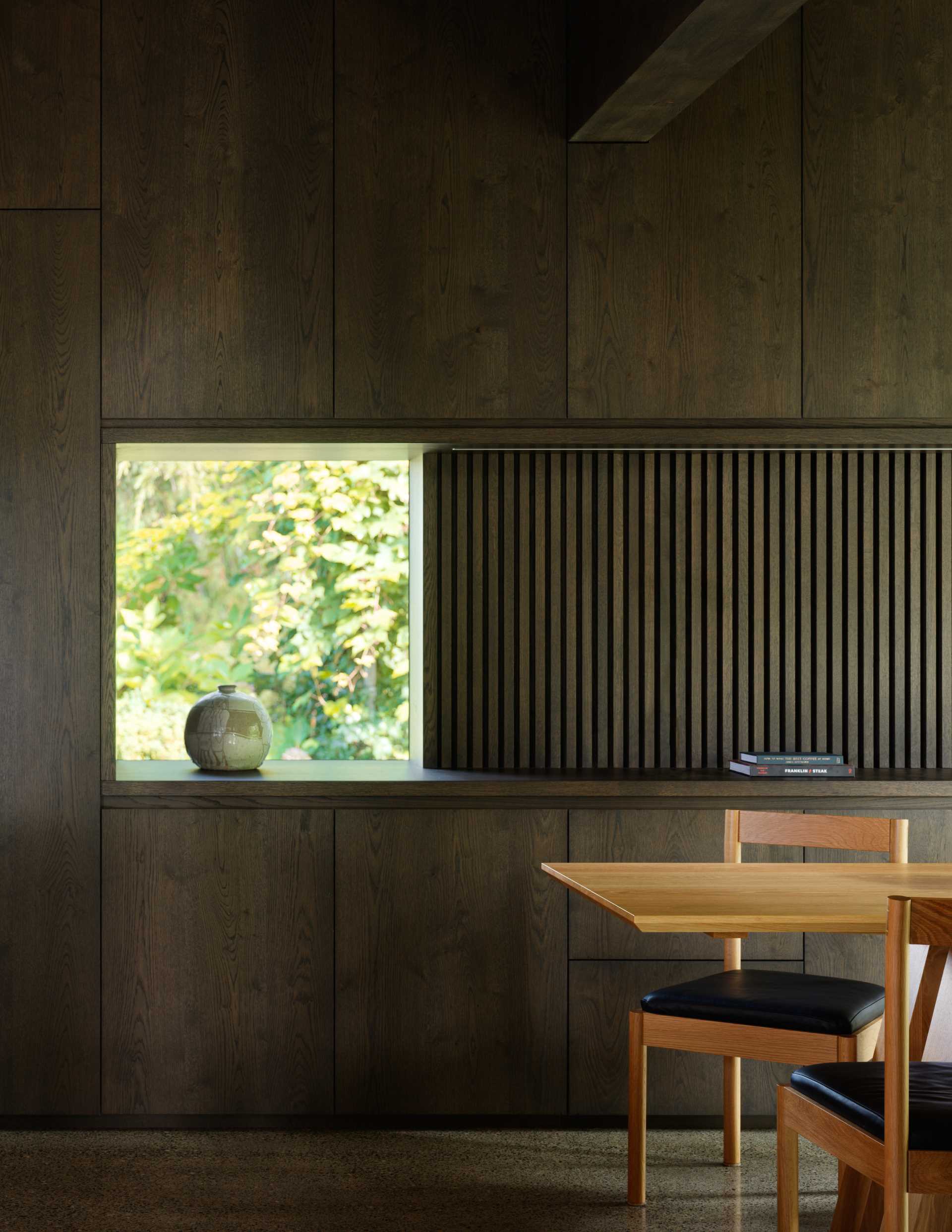 A contemporary breakfast nook with a large picture window and built-in storage.