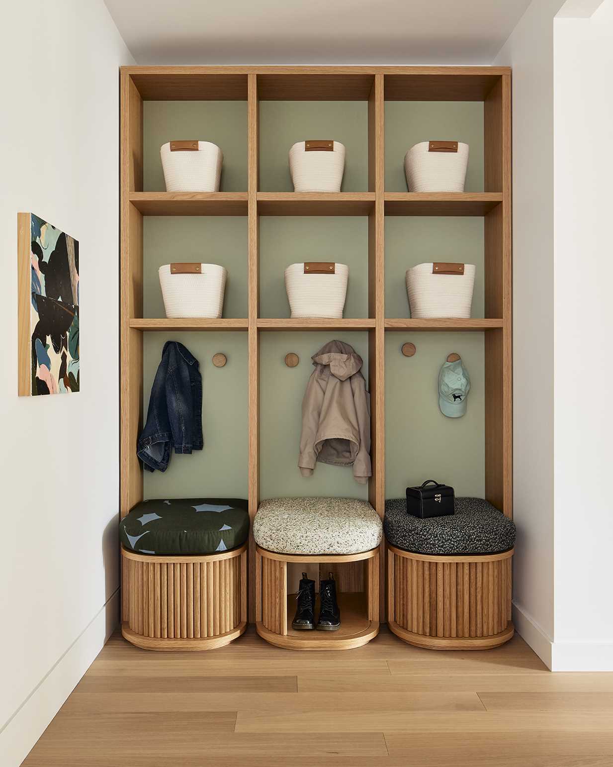 Just off the entryway, a wood shelving unit creates cubbies for each of the children, while small seats have hidden storage within.