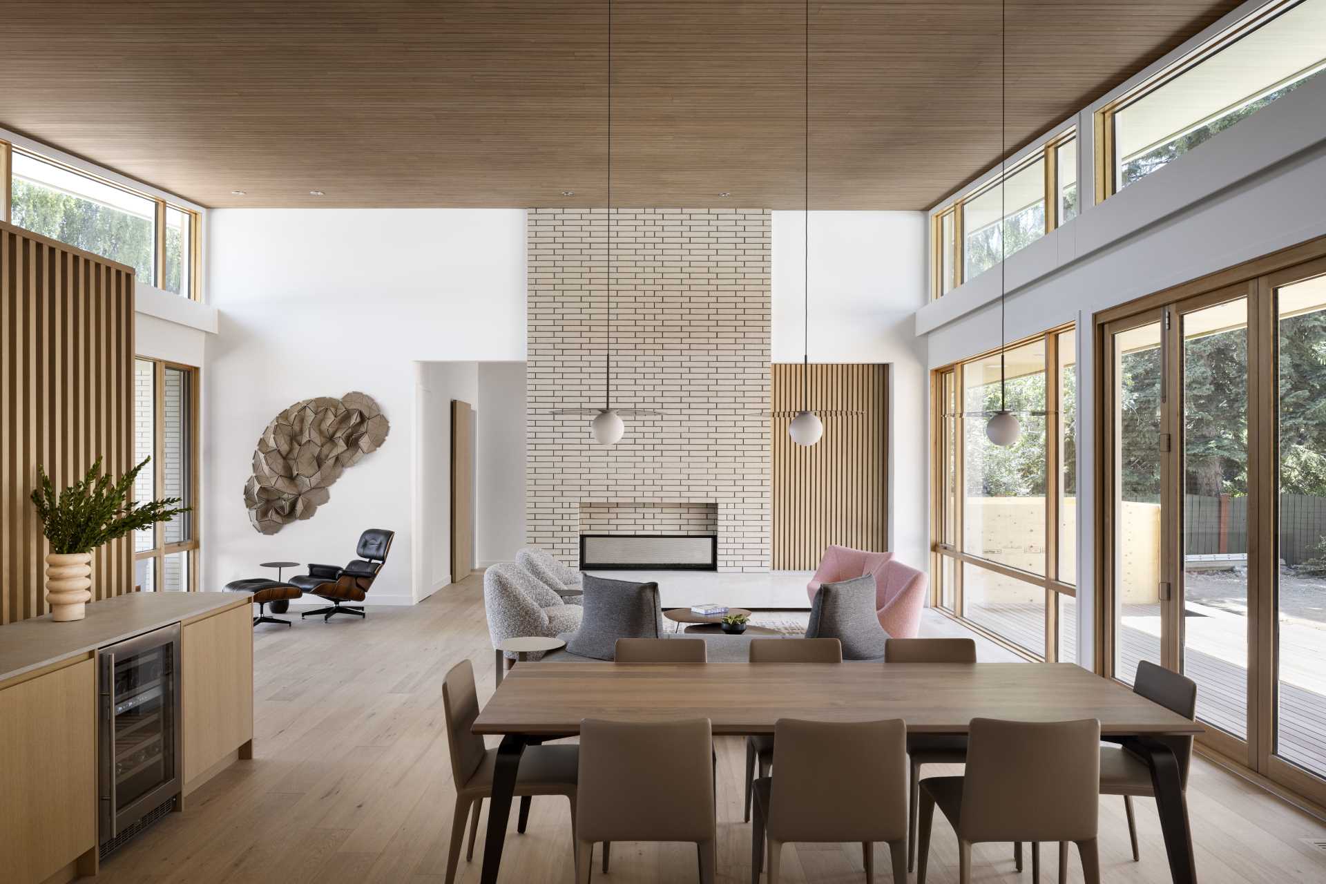 Inside, the central great room is the focal point, with vaulted ceilings clad in textured Abodo wood that flows out to the exterior surfaces through clerestory windows.