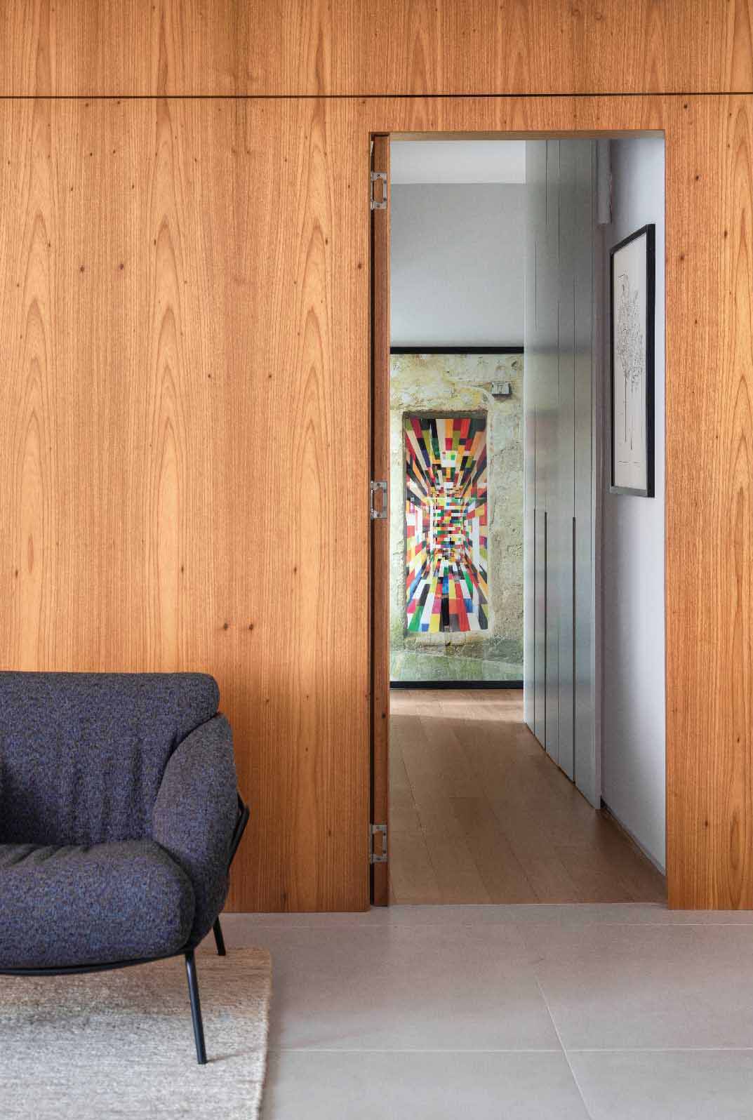 The hallway off the living room was updated and is now accessed via a hidden door in the wood wall at the end of the dining table.