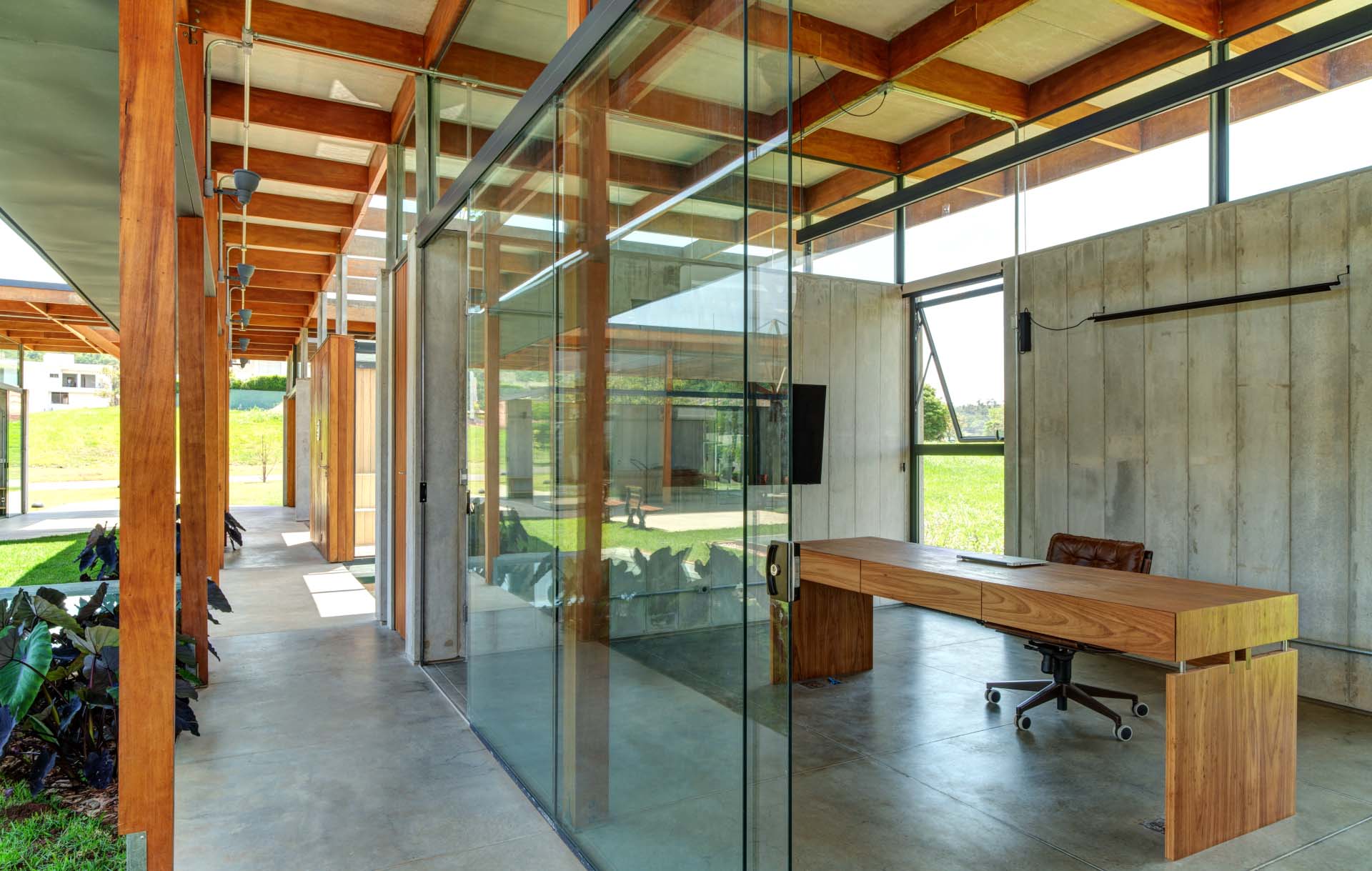 Sliding glass doors and full-height windows keep this home office connected to the outdoor spaces.