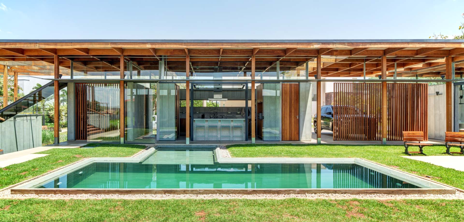 This modern home wraps around a courtyard with a swimming pool, with each room of the house having its own views, while the structure of the home is on full display.