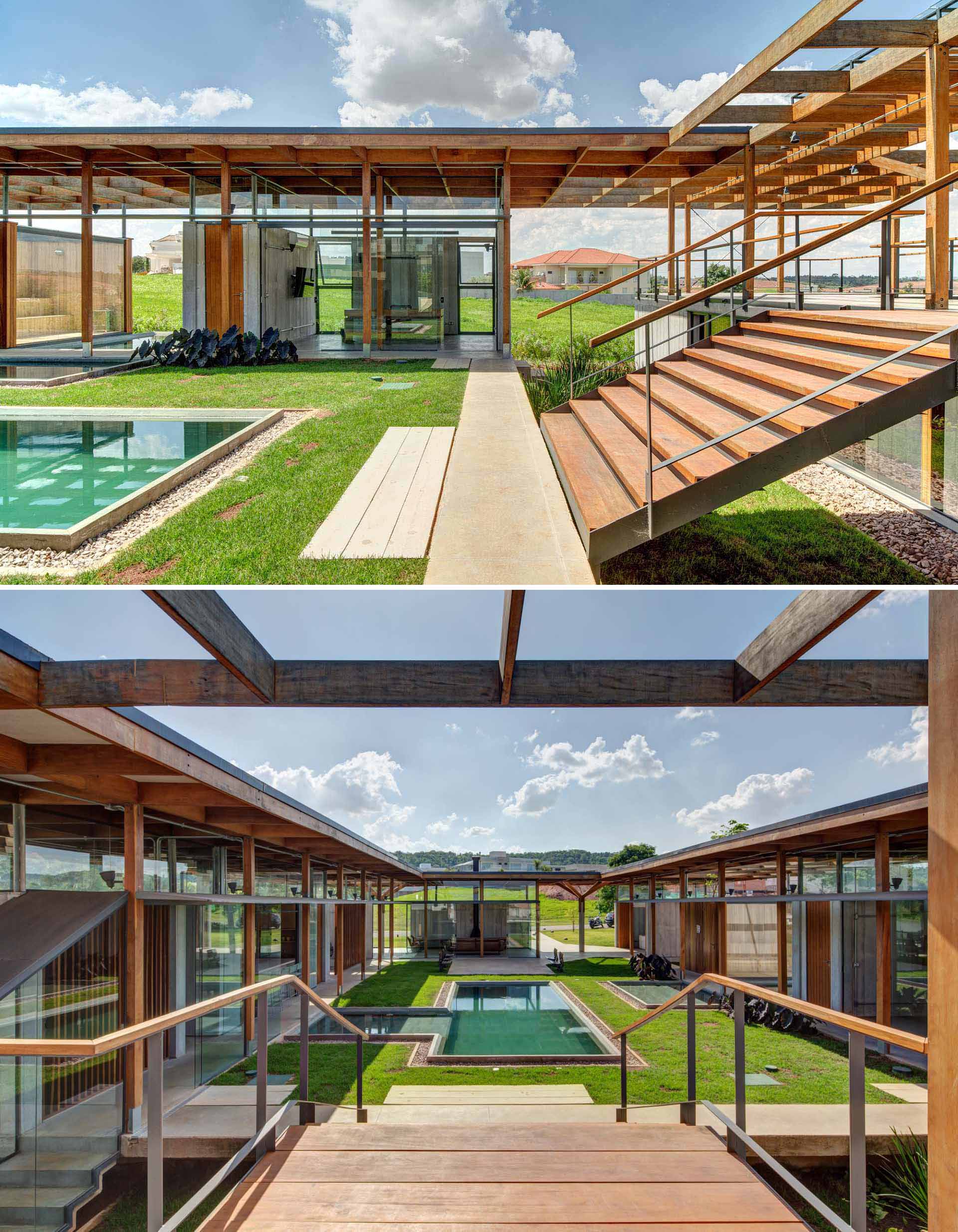 Stairs lead from the lawn and swimming pool up to a rooftop deck that has an outdoor kitchen and dining area. 