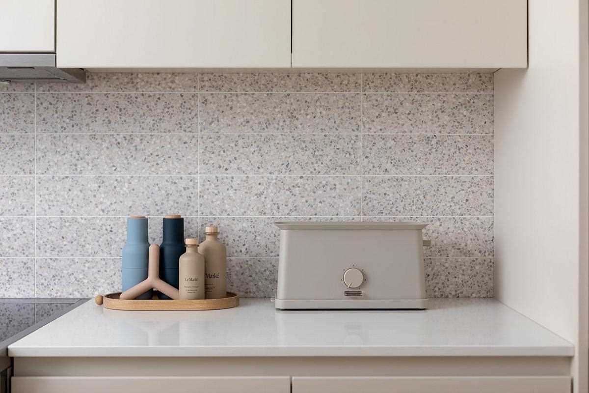 In this modern kitchen, terrazzo tiles add a unique and artistic touch, while hardware-free cabinets and integrated appliances give the space a minimalist appearance.