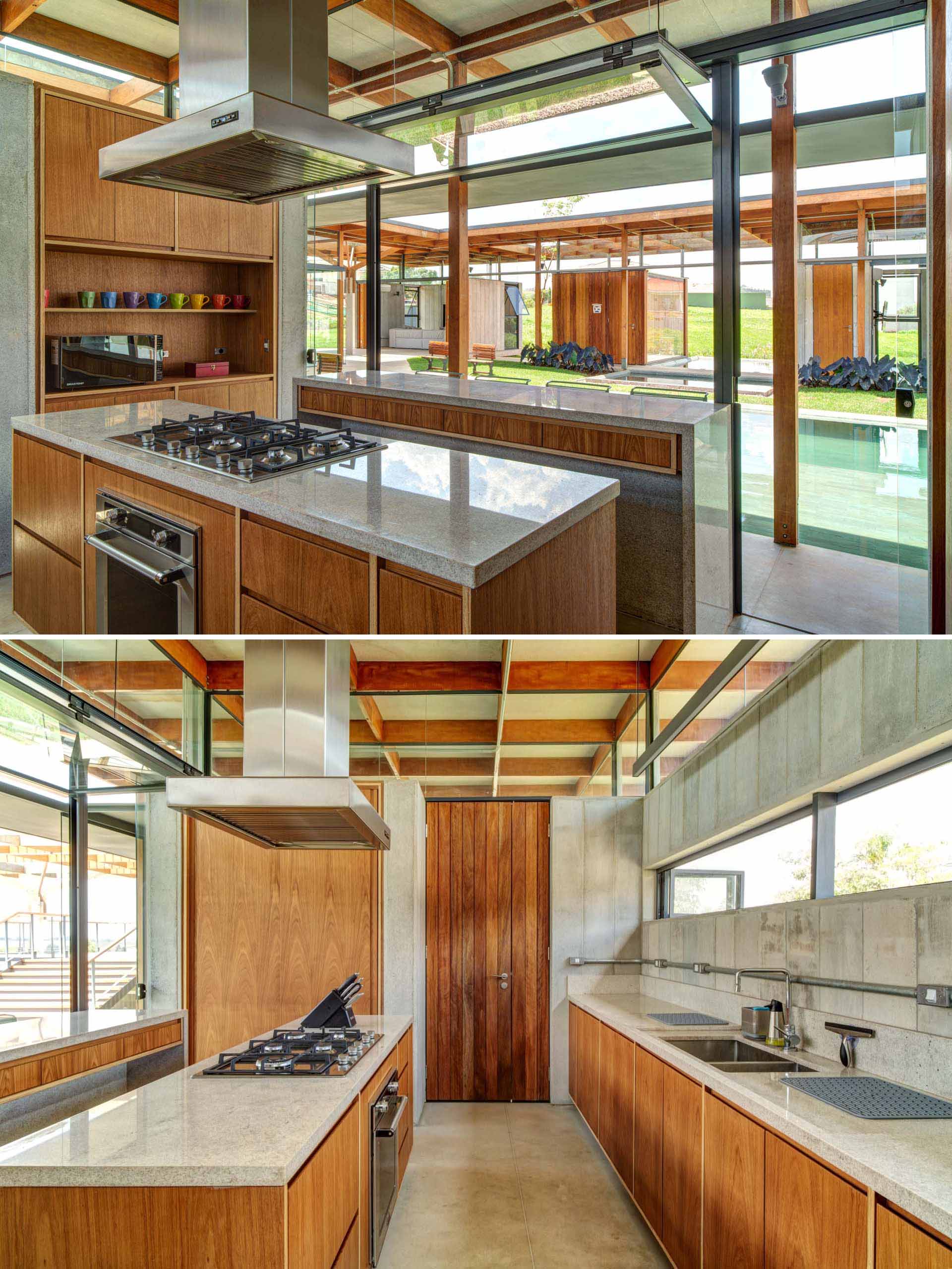 In this modern kitchen, a central island creates plenty of space for cooking, while another island includes a folding window and outdoor seating.