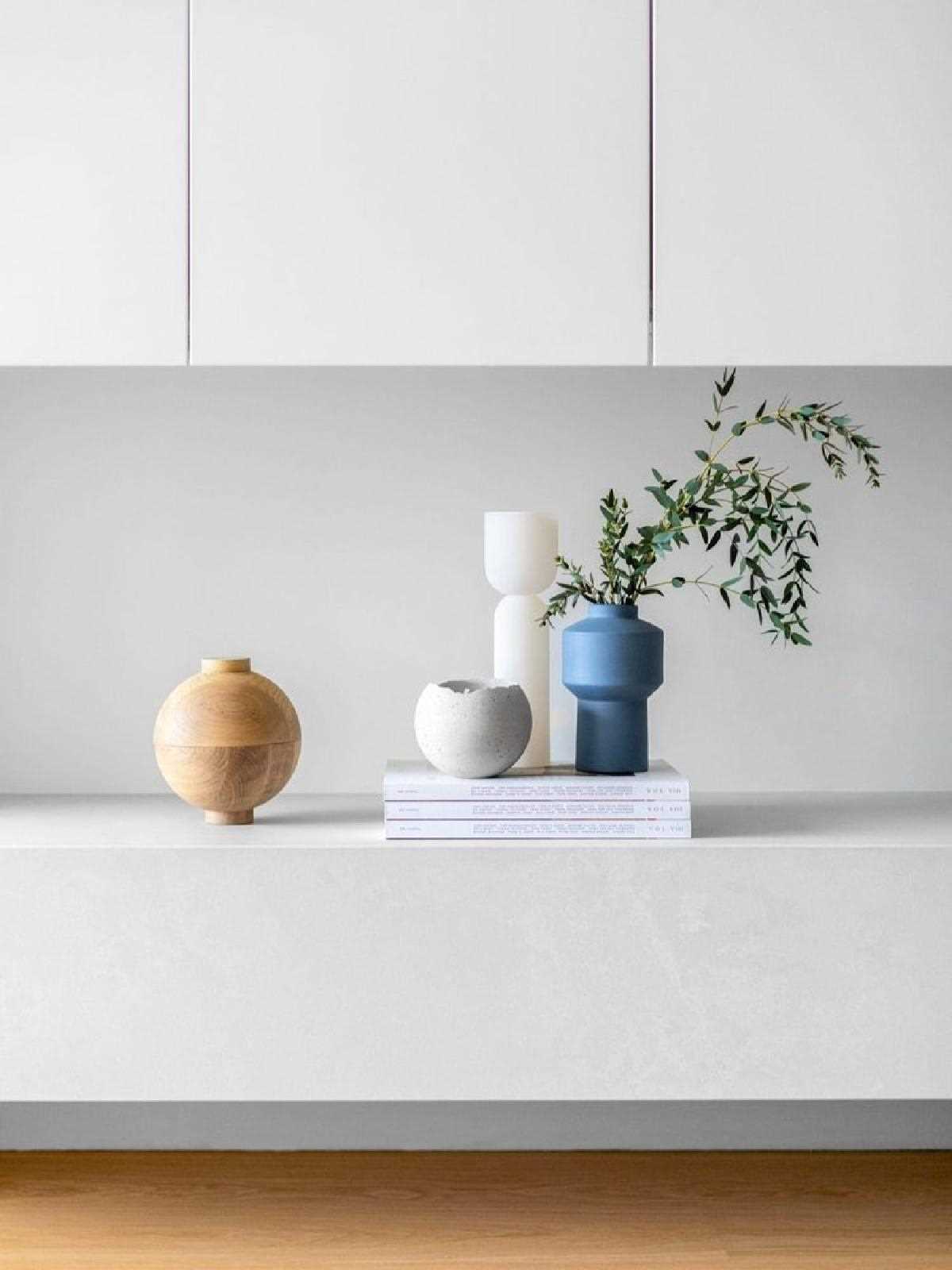 This modern living room has a concrete-hued quartz floating hearth. Bespoke living room millwork conceals the television, upholding a clean and uncluttered aesthetic