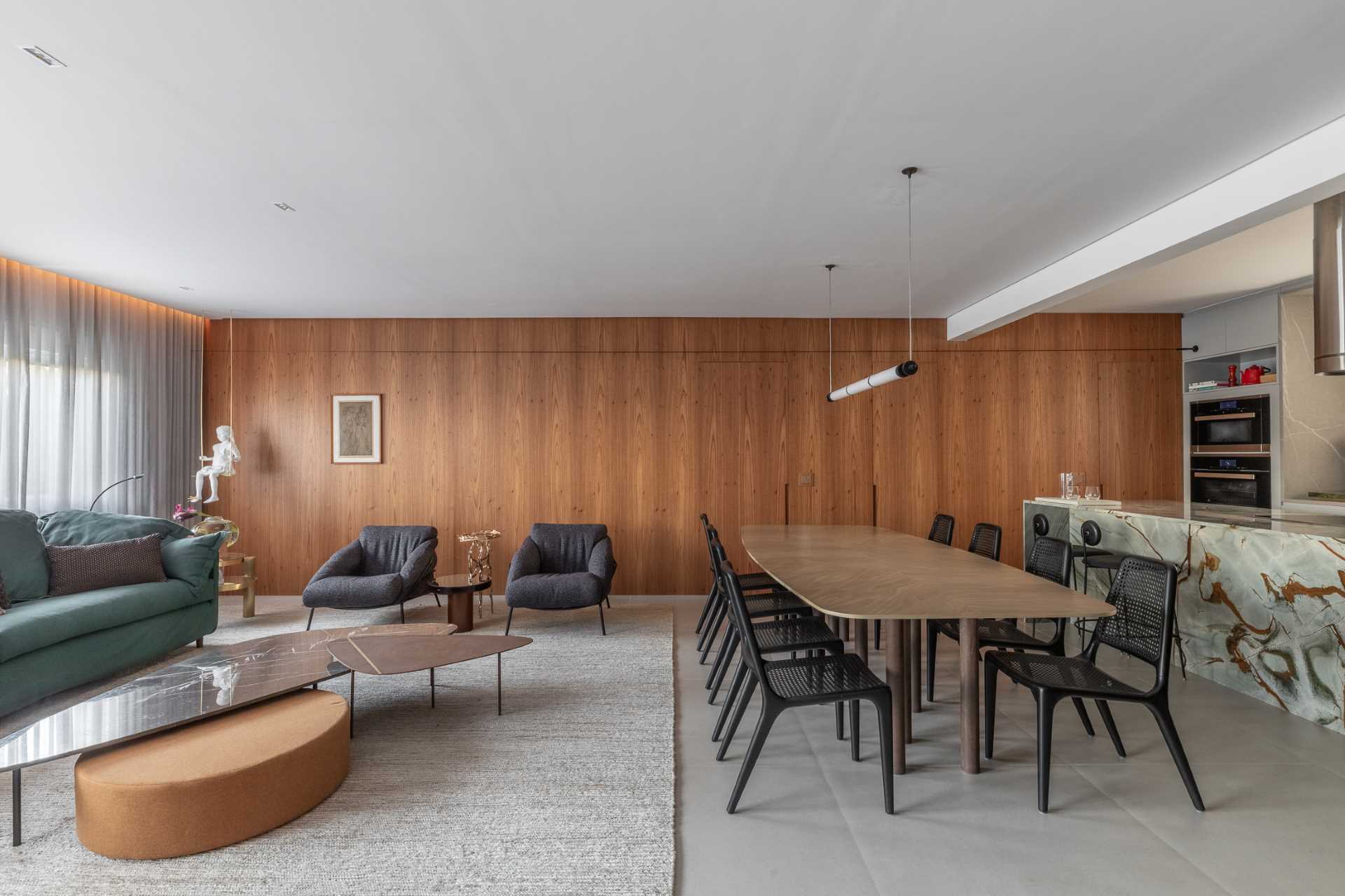 A modern open-plan dining area in a renovated apartment, positioned between the living room and kitchen.