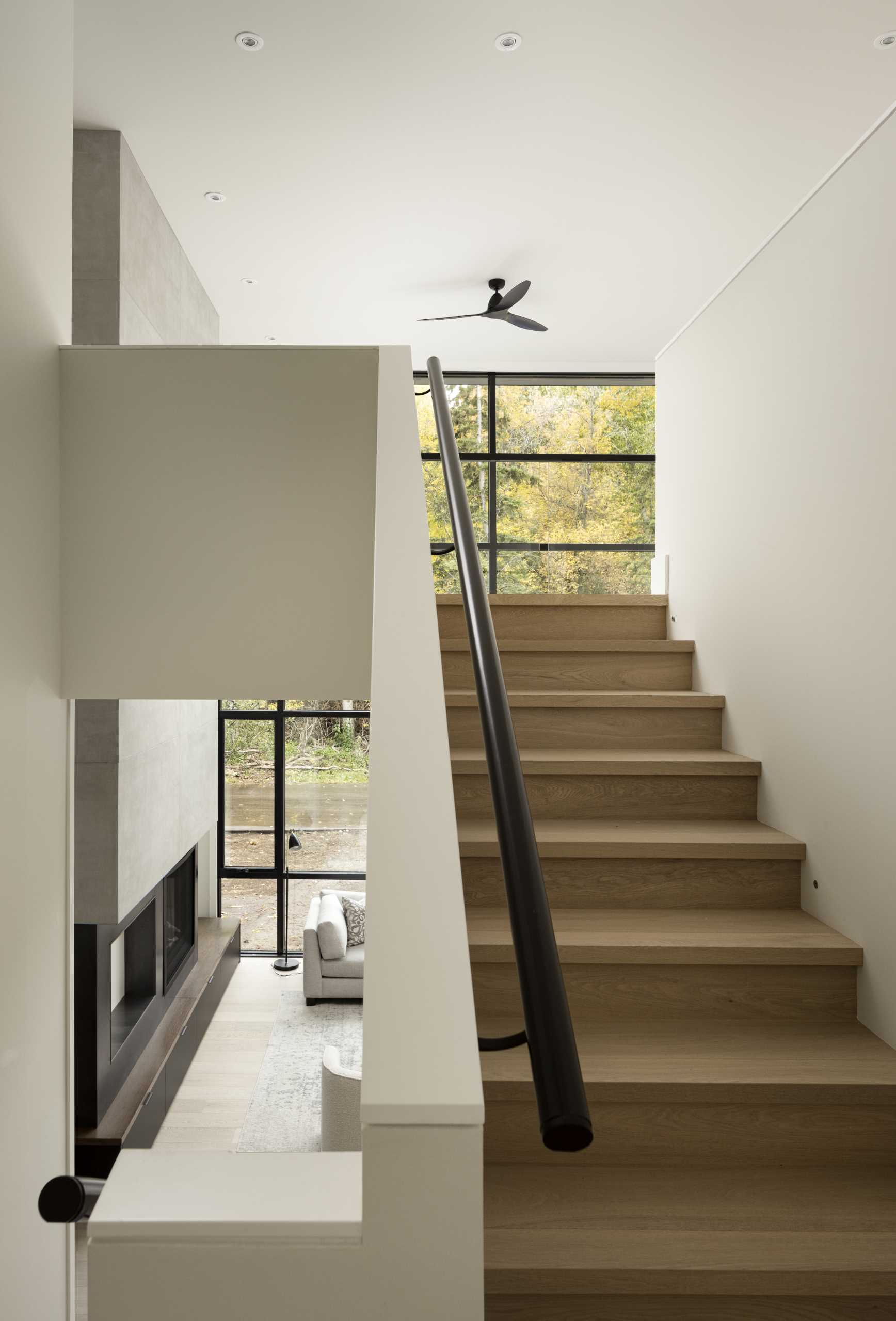 Stairs lead from the main level up to the lofted area, which provides a top-down view of the living room below.