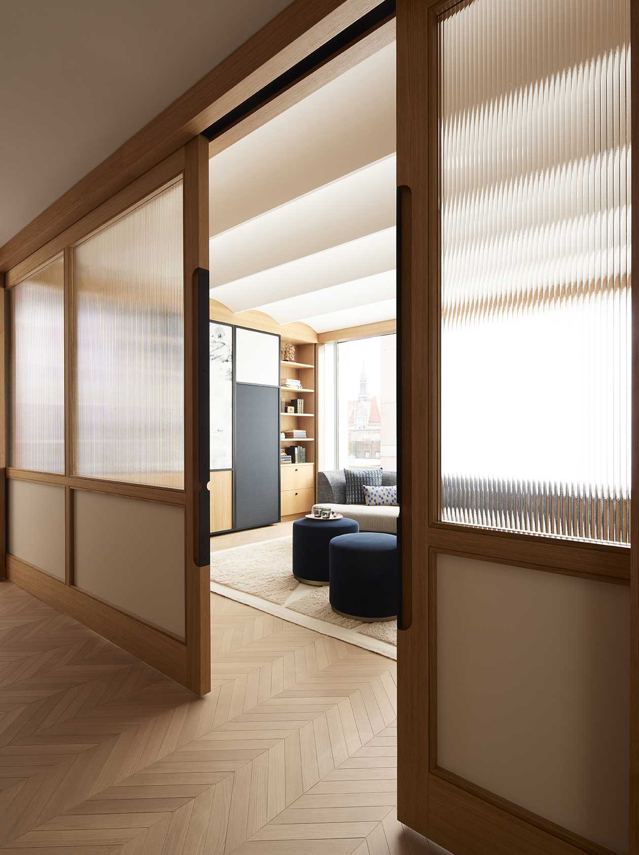 Wood and glass sliding doors allow the library to be open to the other areas of the apartment, or closed off for more privacy when being used as a guest room.