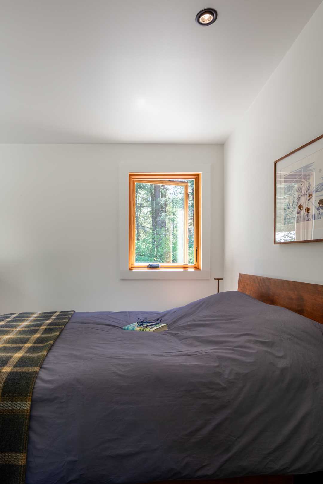 In this bedroom, simple furnishings have been paired with the owner’s collection of art, family heirlooms, and furniture gathered over many years.