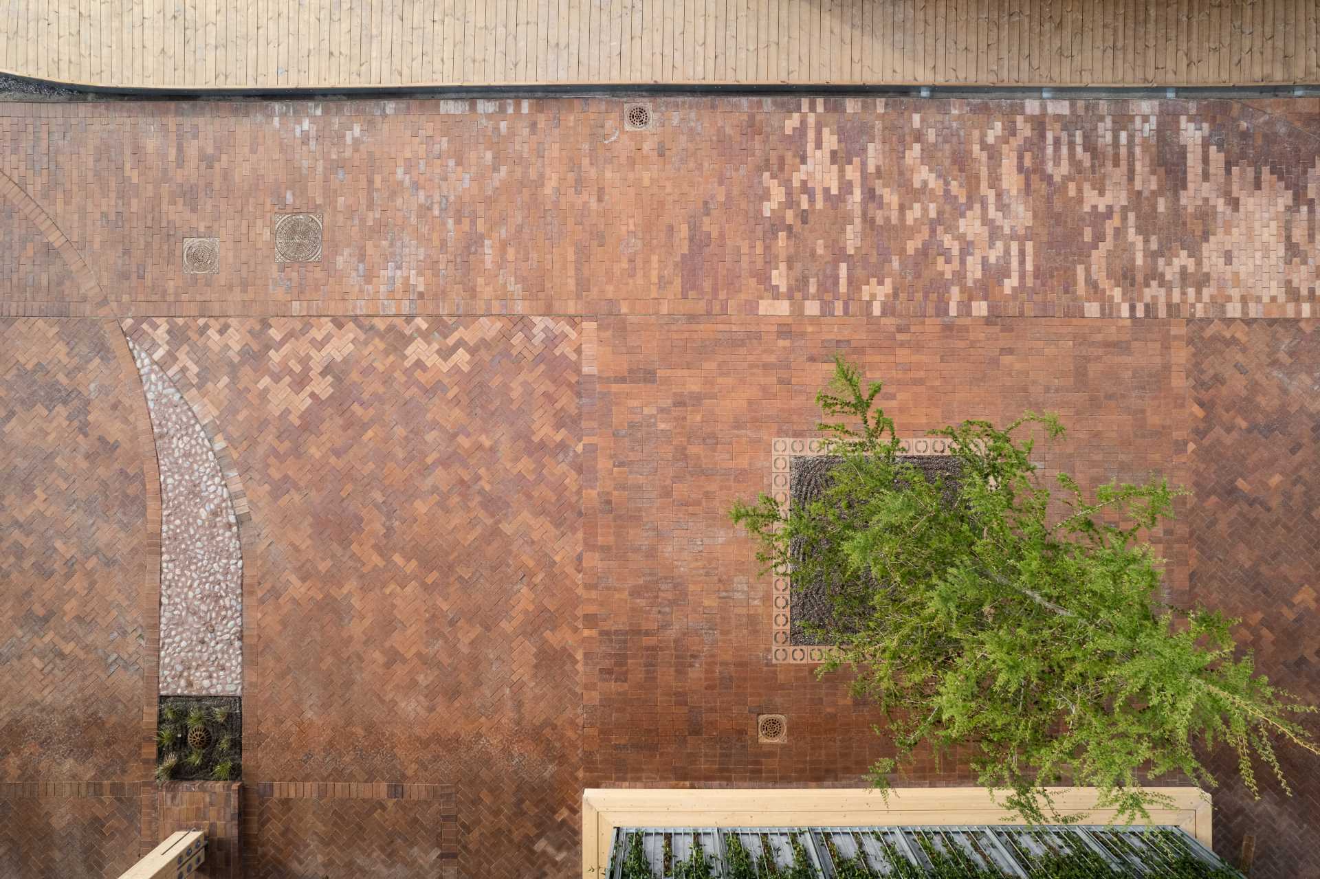 The brick paving and landscaping around a charging station.