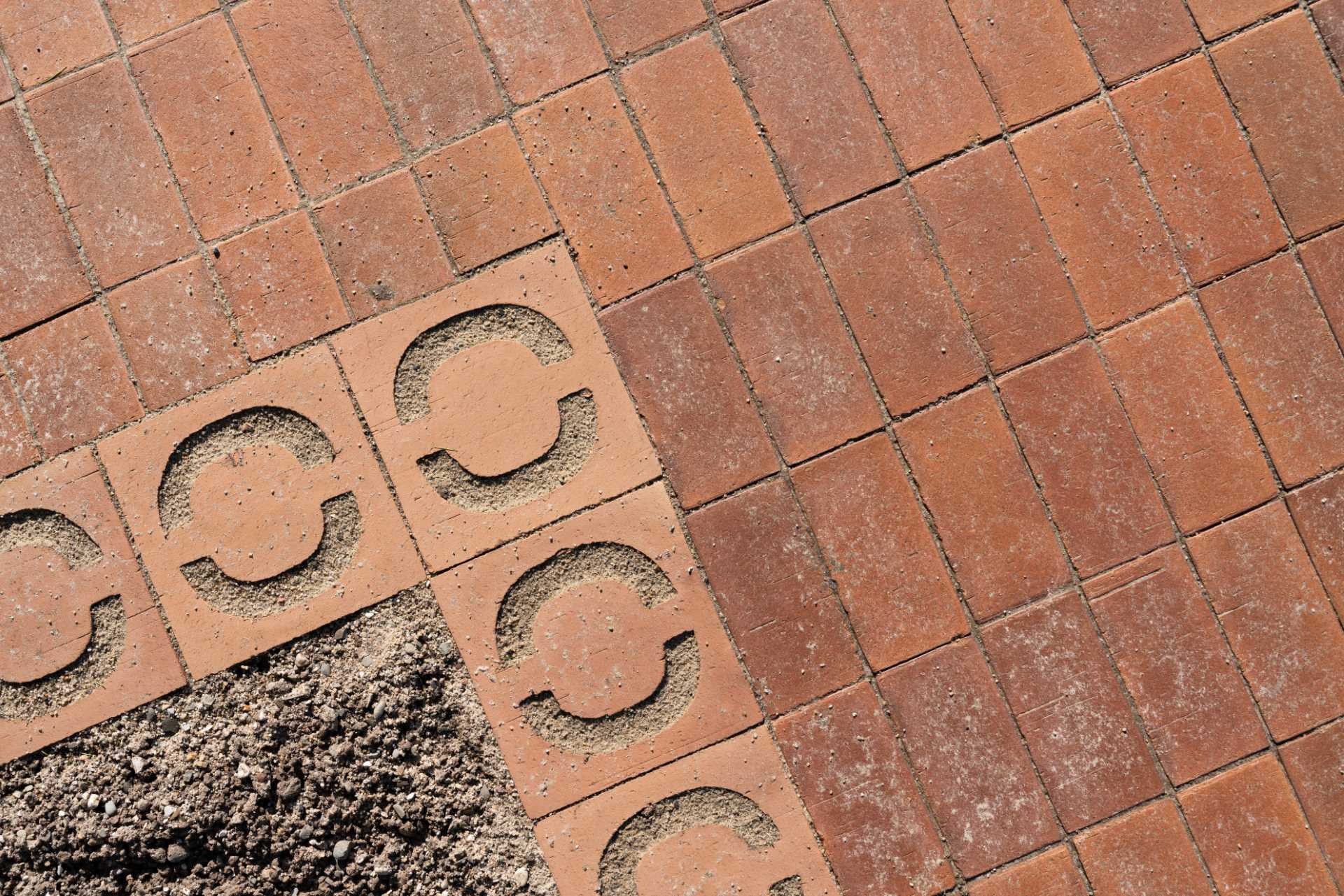 The brick paving and landscaping around a charging station.