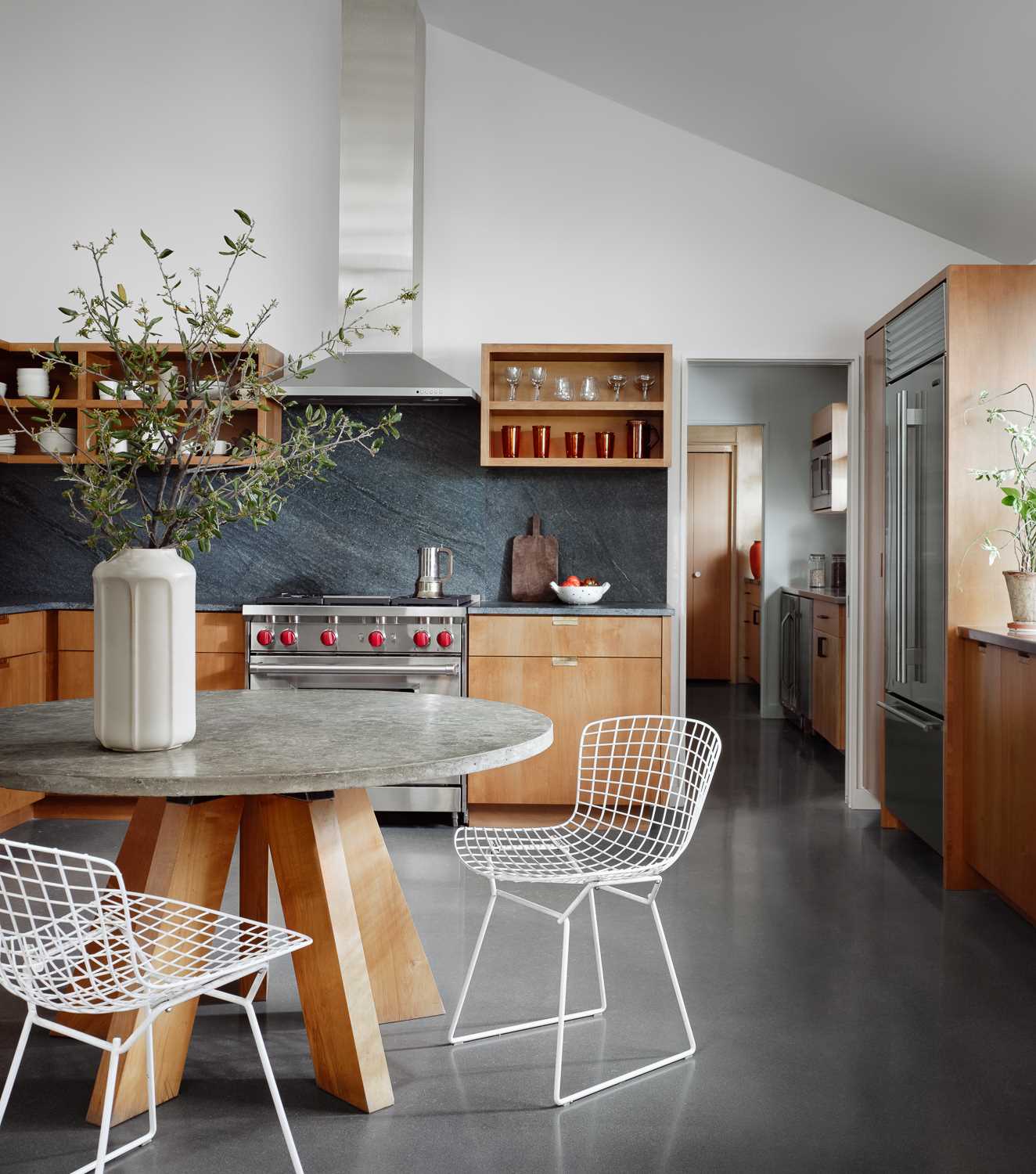 The dining area and kitchen share the same space as the living room. The kitchen features a soapstone countertop and backsplash, while the adjacent large butlers pantry was remodelled from the original space.