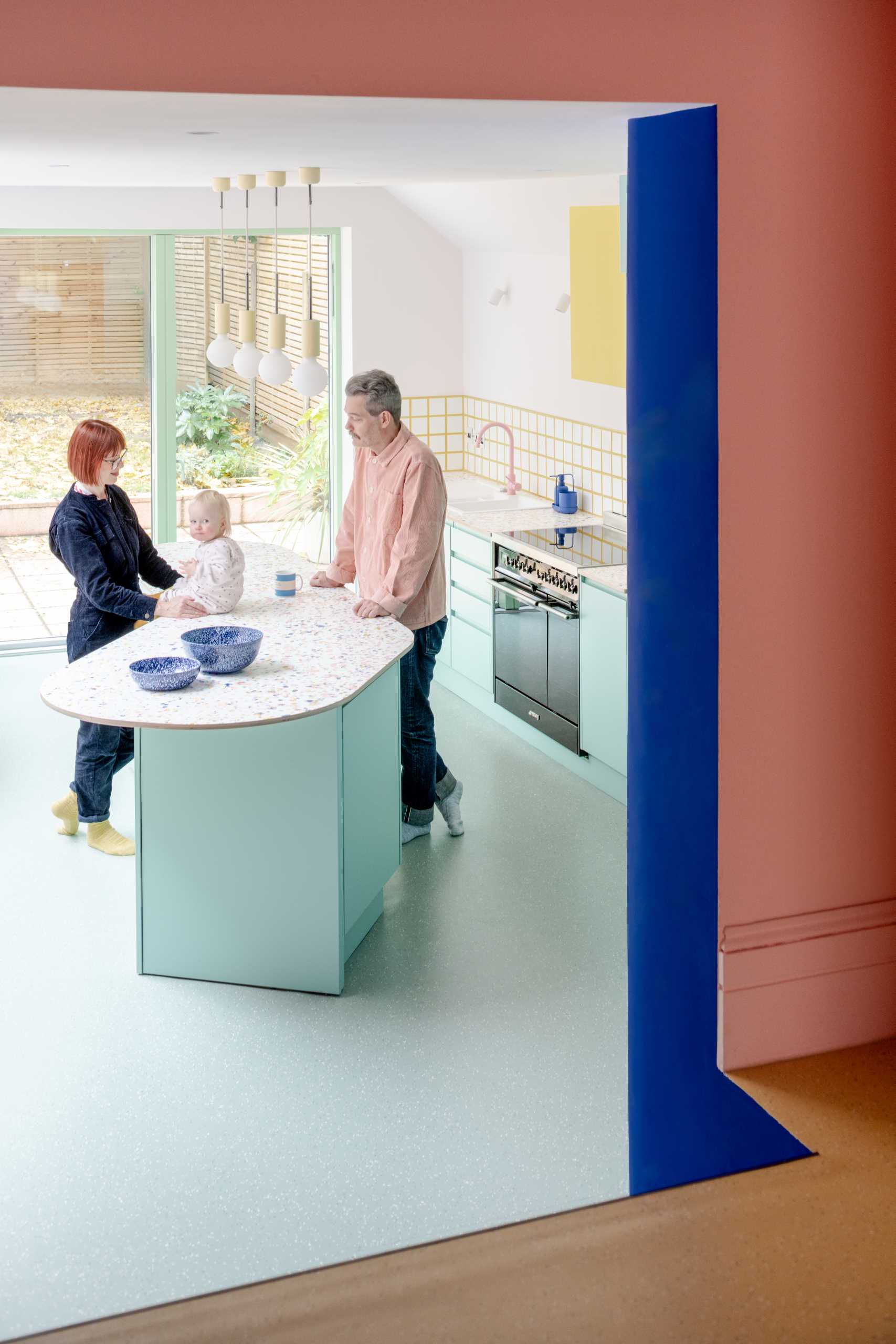 Inside the new addition, bespoke patterned worktops were ordered for the kitchen, which complement the pastel green cabinets, while the soft banquette seating was sewn by a local upholsterer.