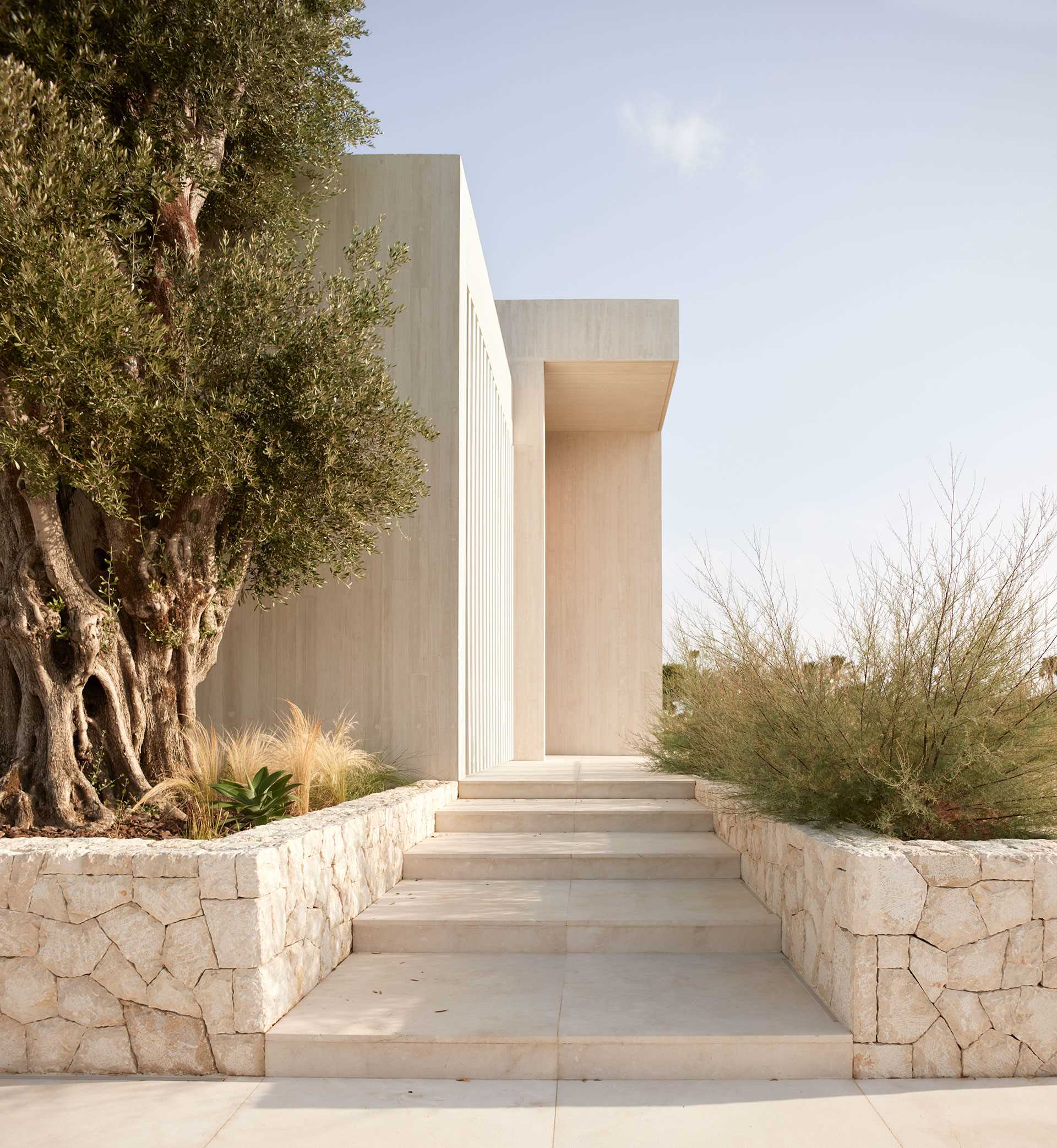 Low stone walls provide a textural element to this modern home's surroundings.