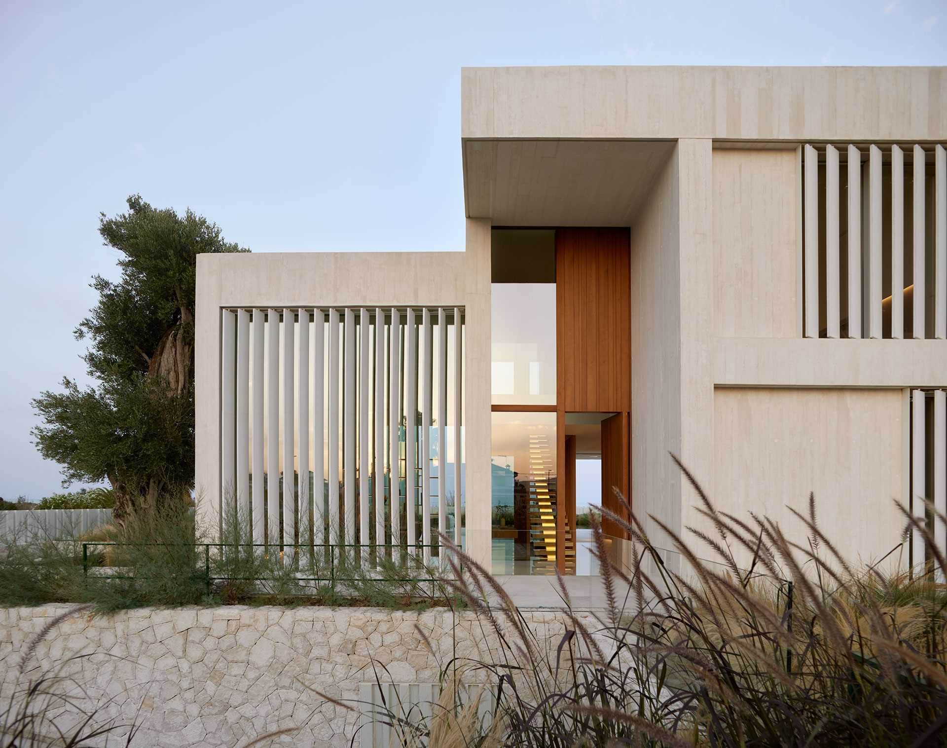 Low stone walls provide a textural element to this modern home's surroundings.